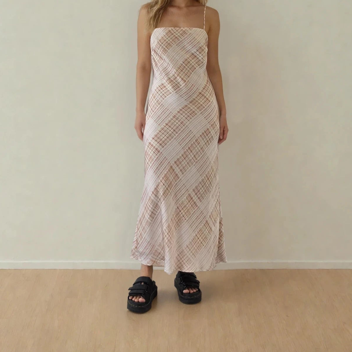 Image of woman wearing the checkmate slip dress, showing the rust coloured checked print on cream