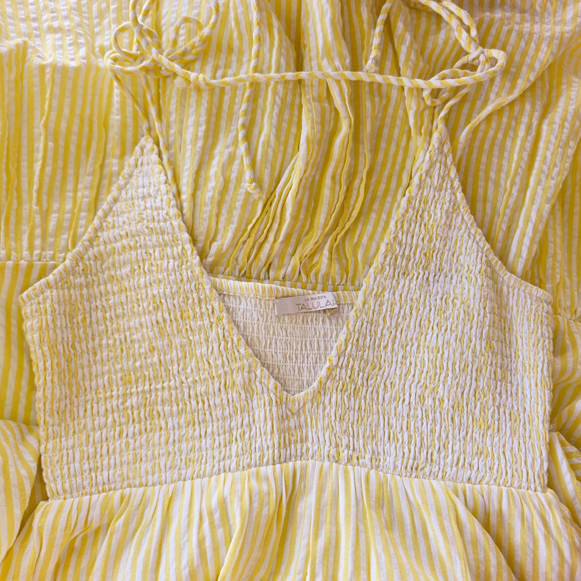 Front view of the La Maison Talulah Layla Dress, showing the back ruched detail, tie straps and fresh yellow and white stripes.