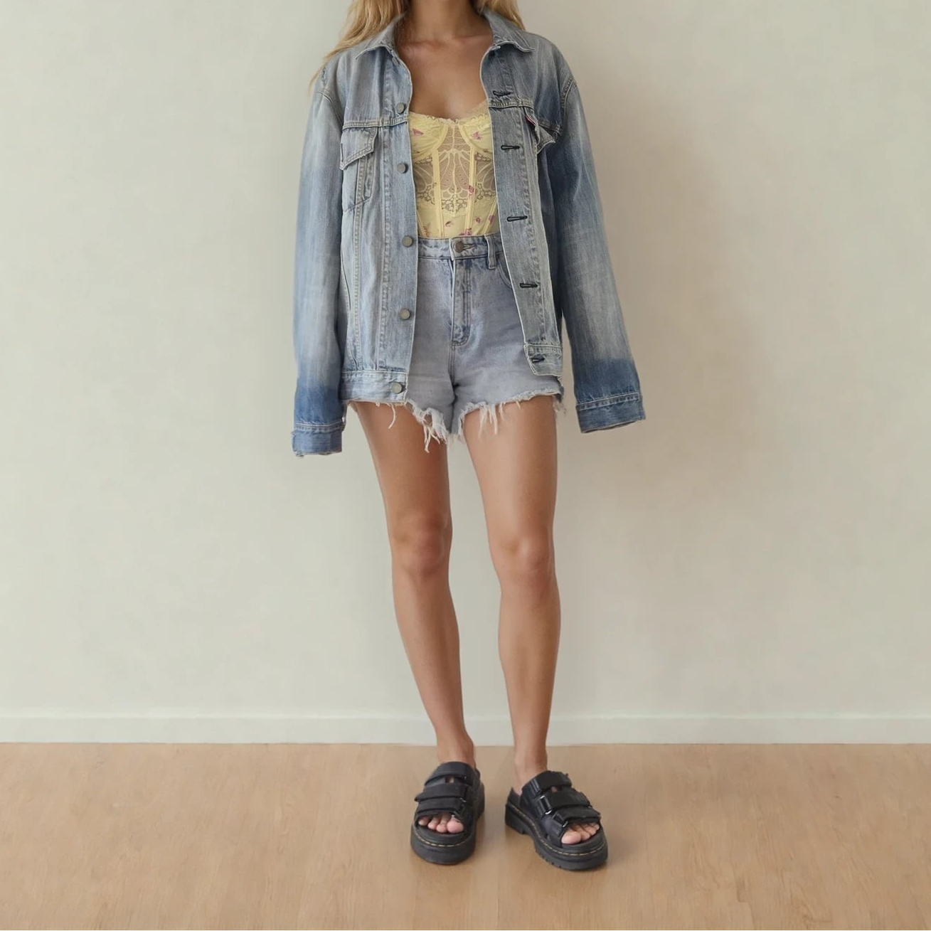 Image of the front of the Levis denim trucker jacket, showing the faded wash, button front and pockets