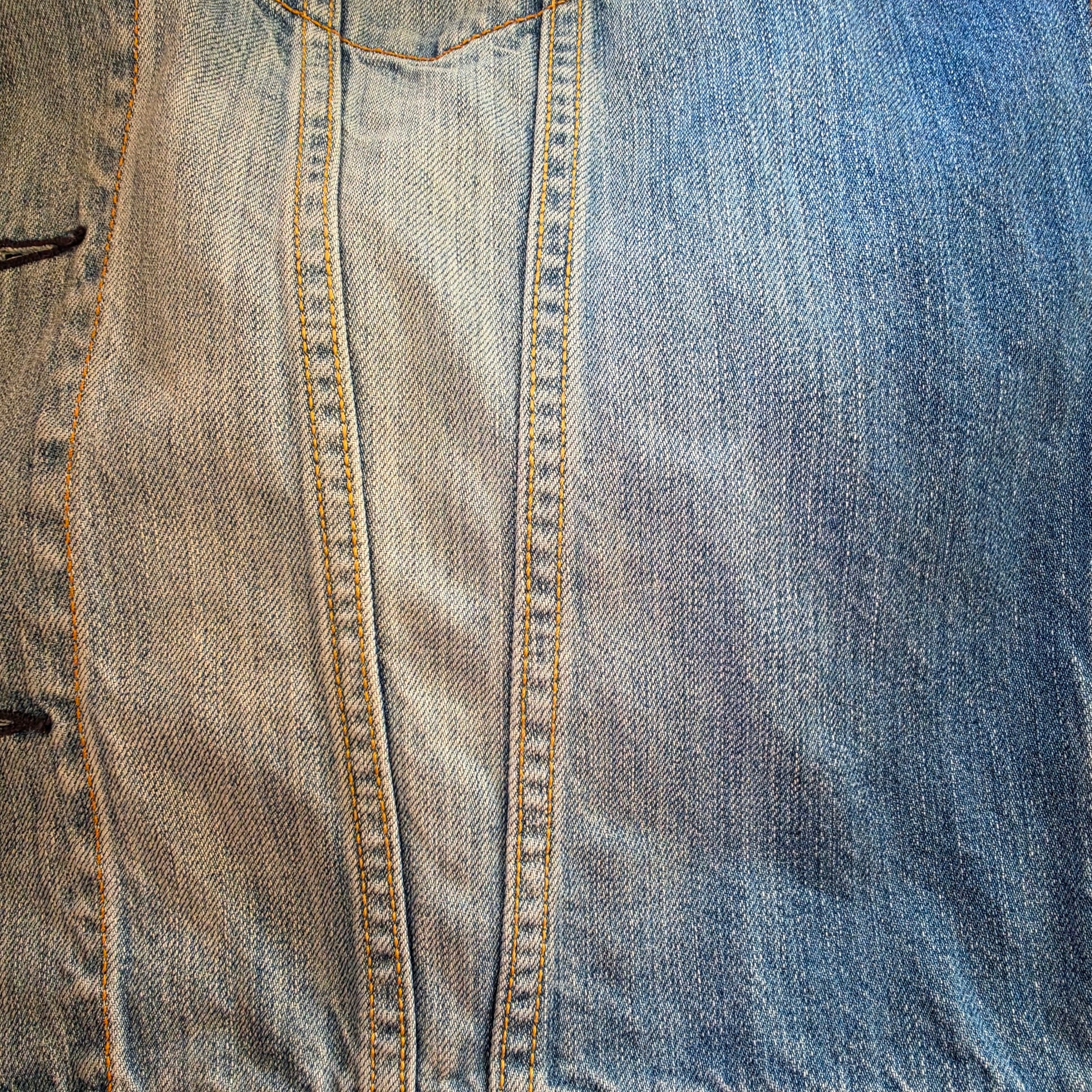 Close-up of blue denim Levis trucker jacket, showing the factory fading and contrast stitching details
