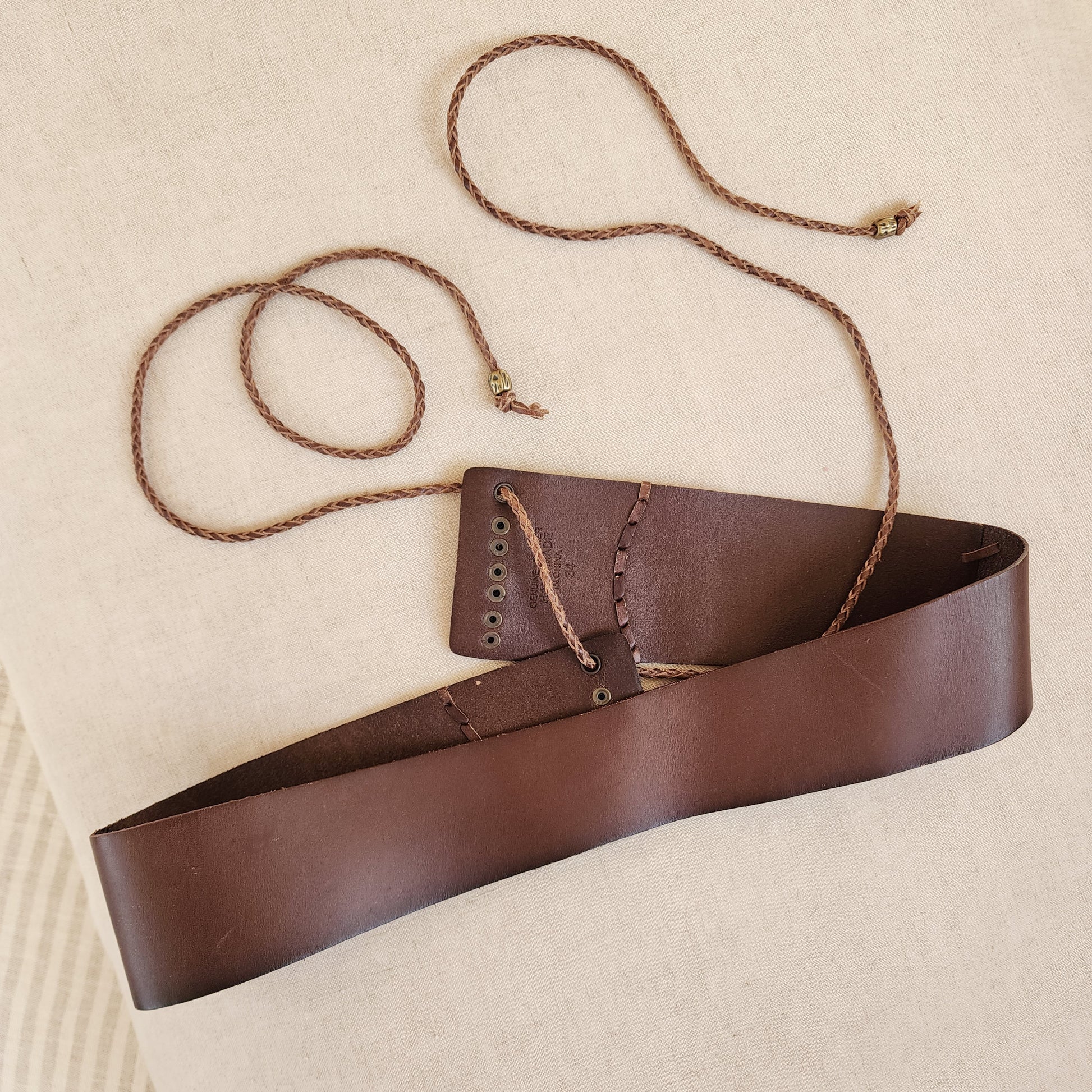 Corset style tie fastening detail on brown leather belt