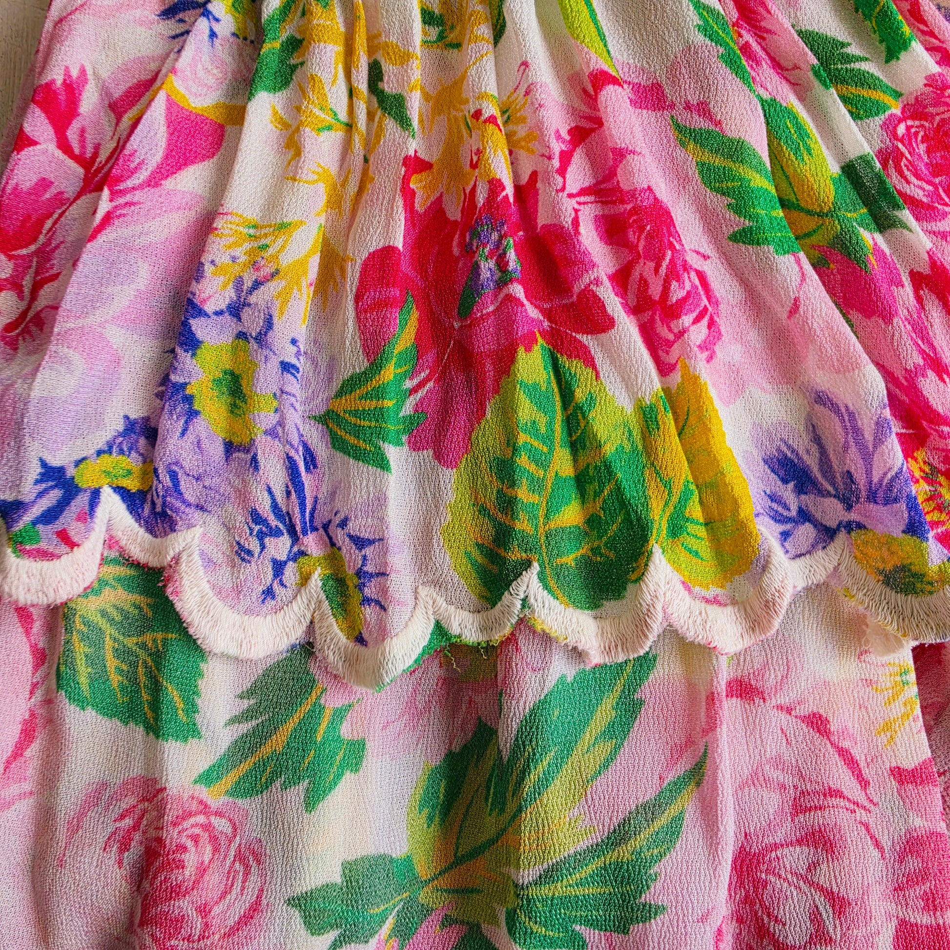 Close-up of the scalloped embroidered hem and vibrant floral print on the Miss June Paris Holly dress.