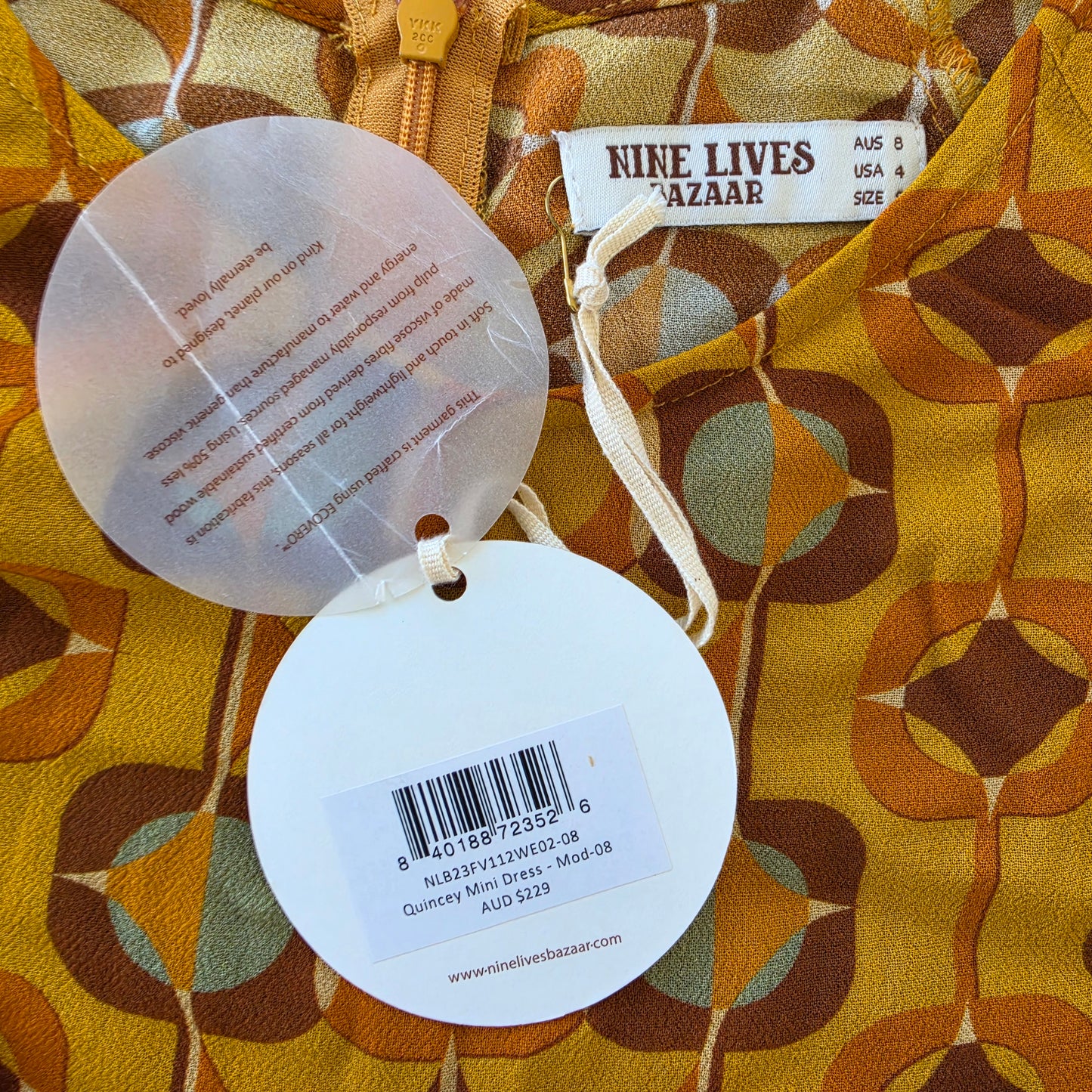 Close up view of the swing tags on the Nine Lives Bazaar Quincy Mini Dress, show rrp $229