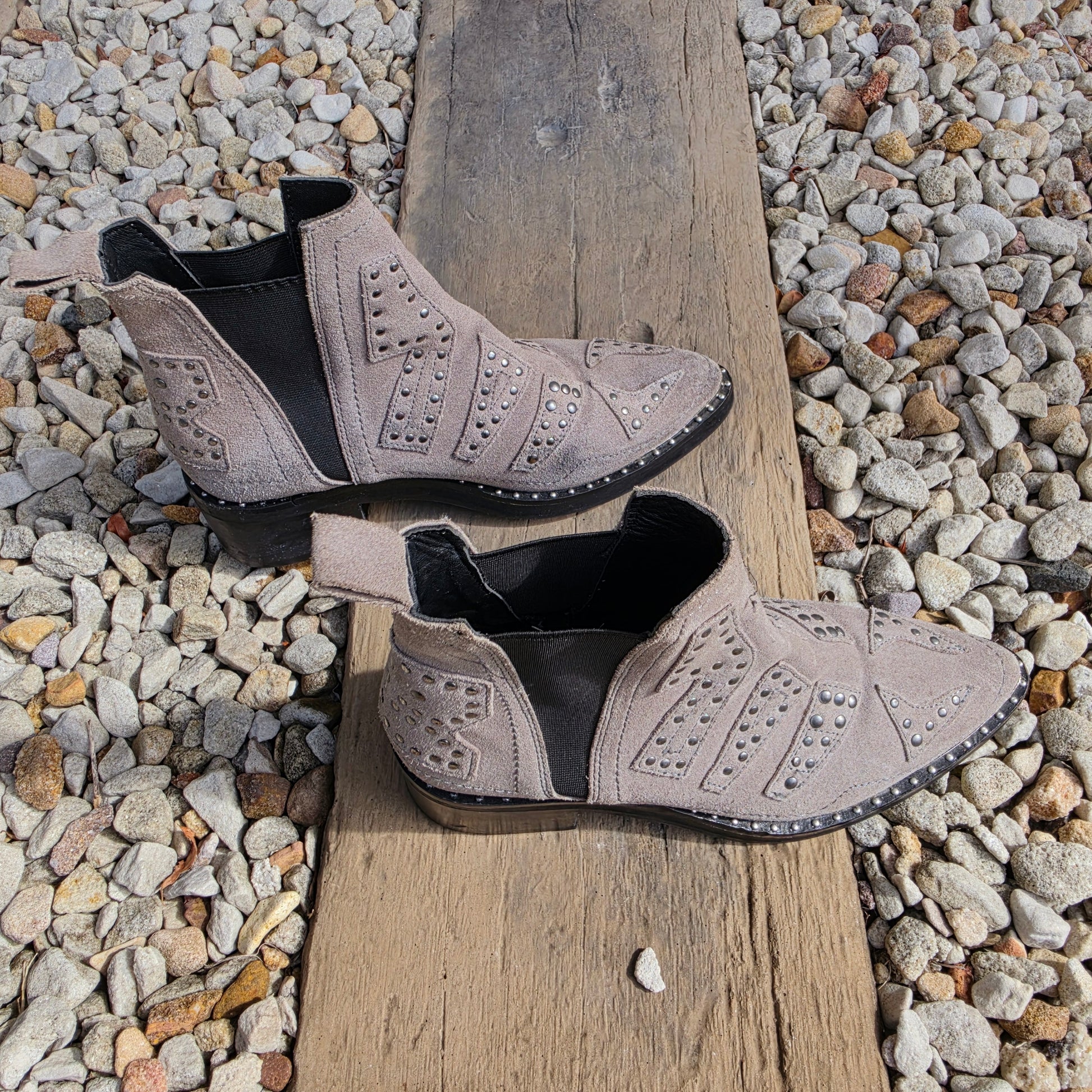 Angled view of studded suede One Teaspoon ankle boots styled outdoors