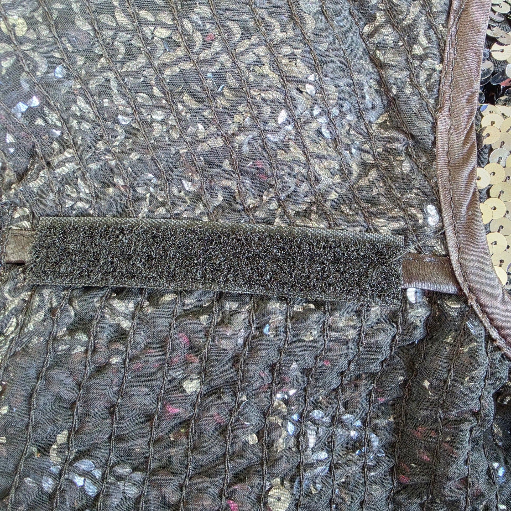 Close-up of shoulder pad velcro inside vintage Peer Gynt sequin jacket.
