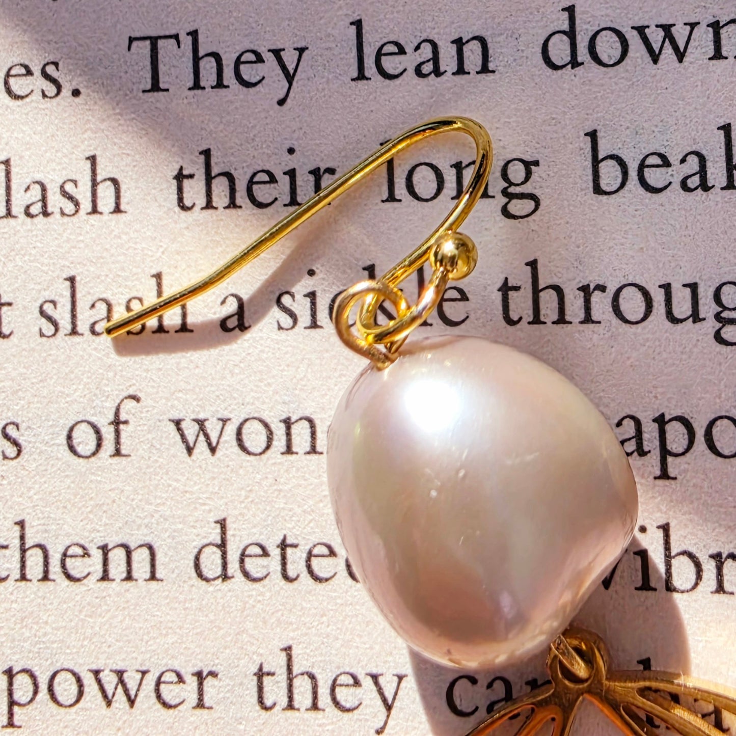 Image showing the close up detail and minor scuffing on the pearl on Qoqa earrings.