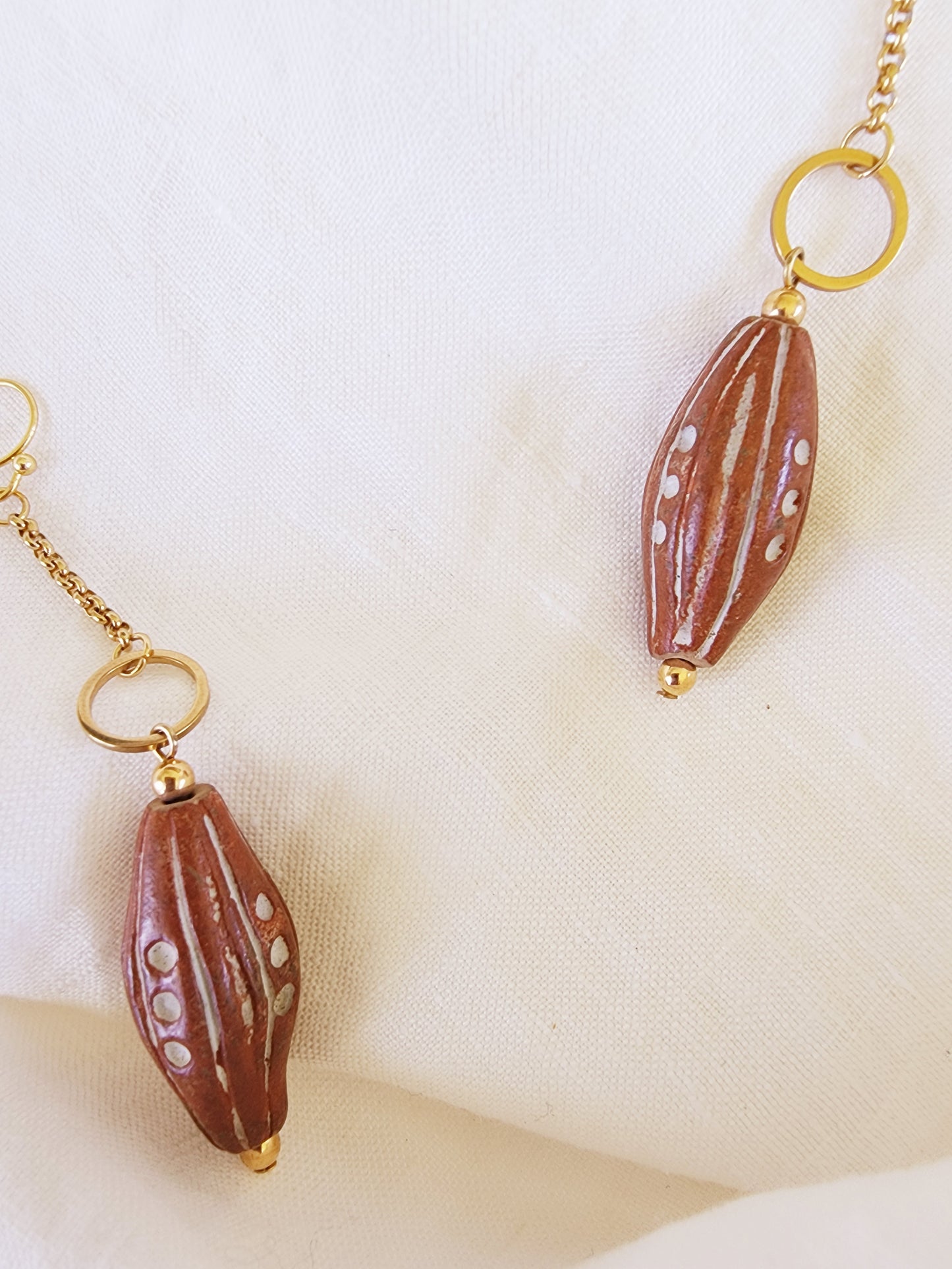 Side angle showing the length and movement of The Ramblers clay bead earrings with gold-plated findings.