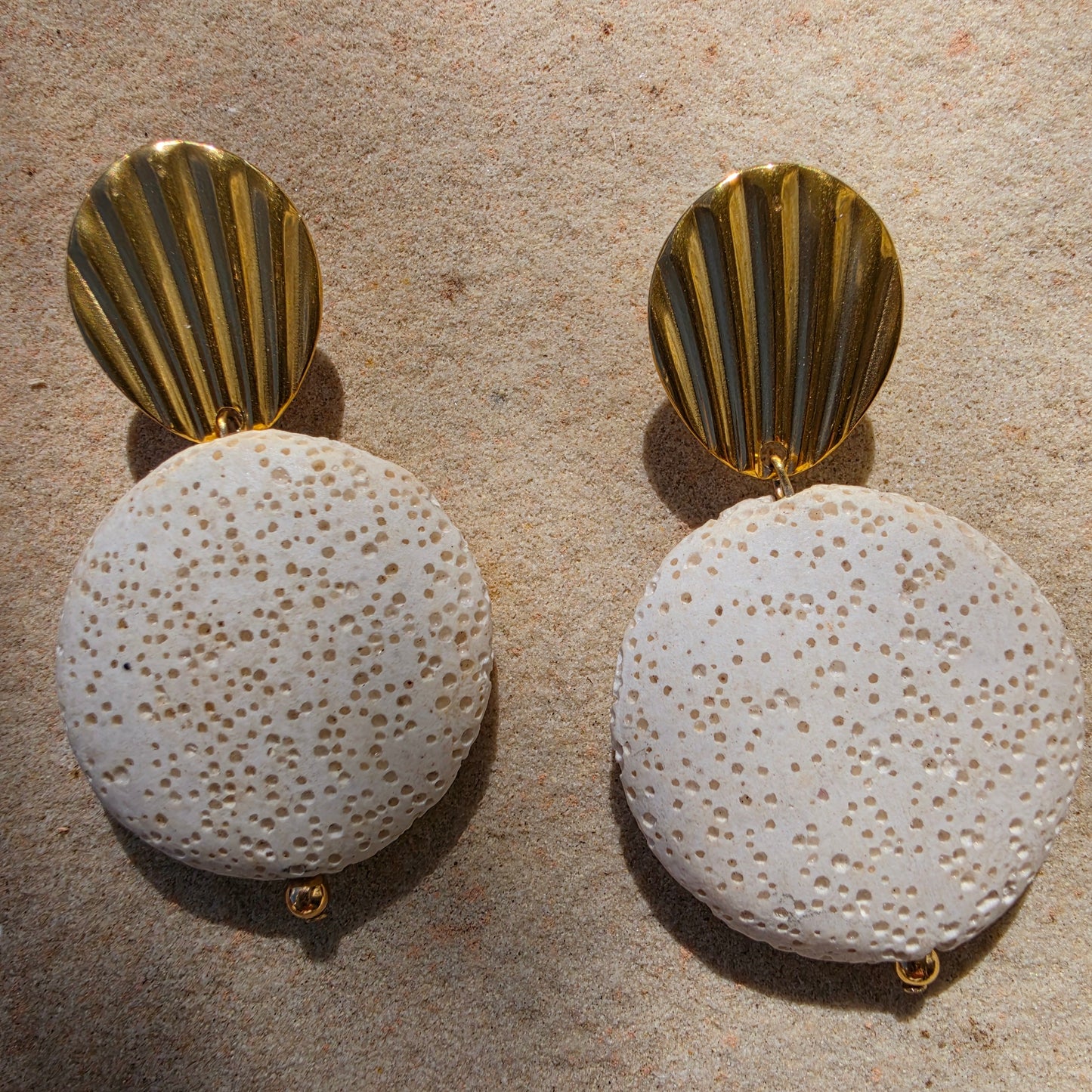 Close up view of the textured Lumen earrings, part of the Relic collection, showing the gold plated components.