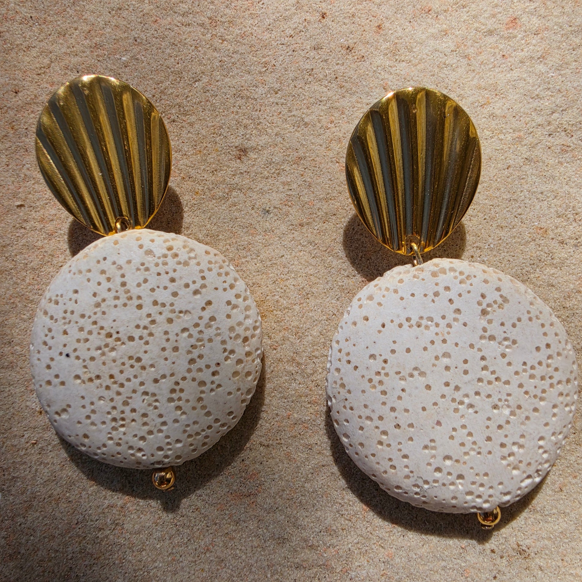 Close up view of the textured Lumen earrings, part of the Relic collection, showing the gold plated components.