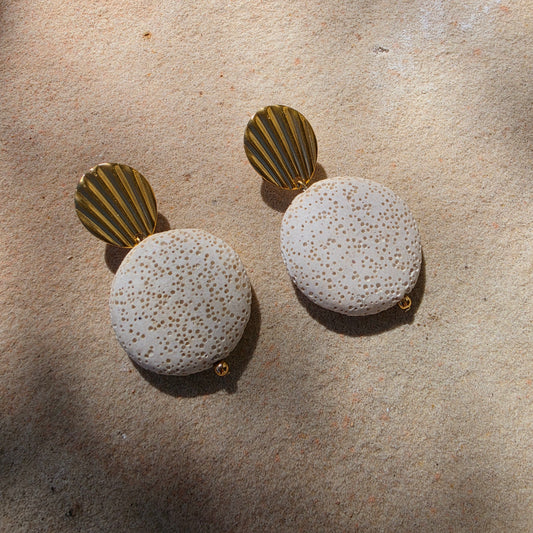 Front view of the Lumen Crema earring, part of the Relic collection, showing the shell like gold plated component and textured surface