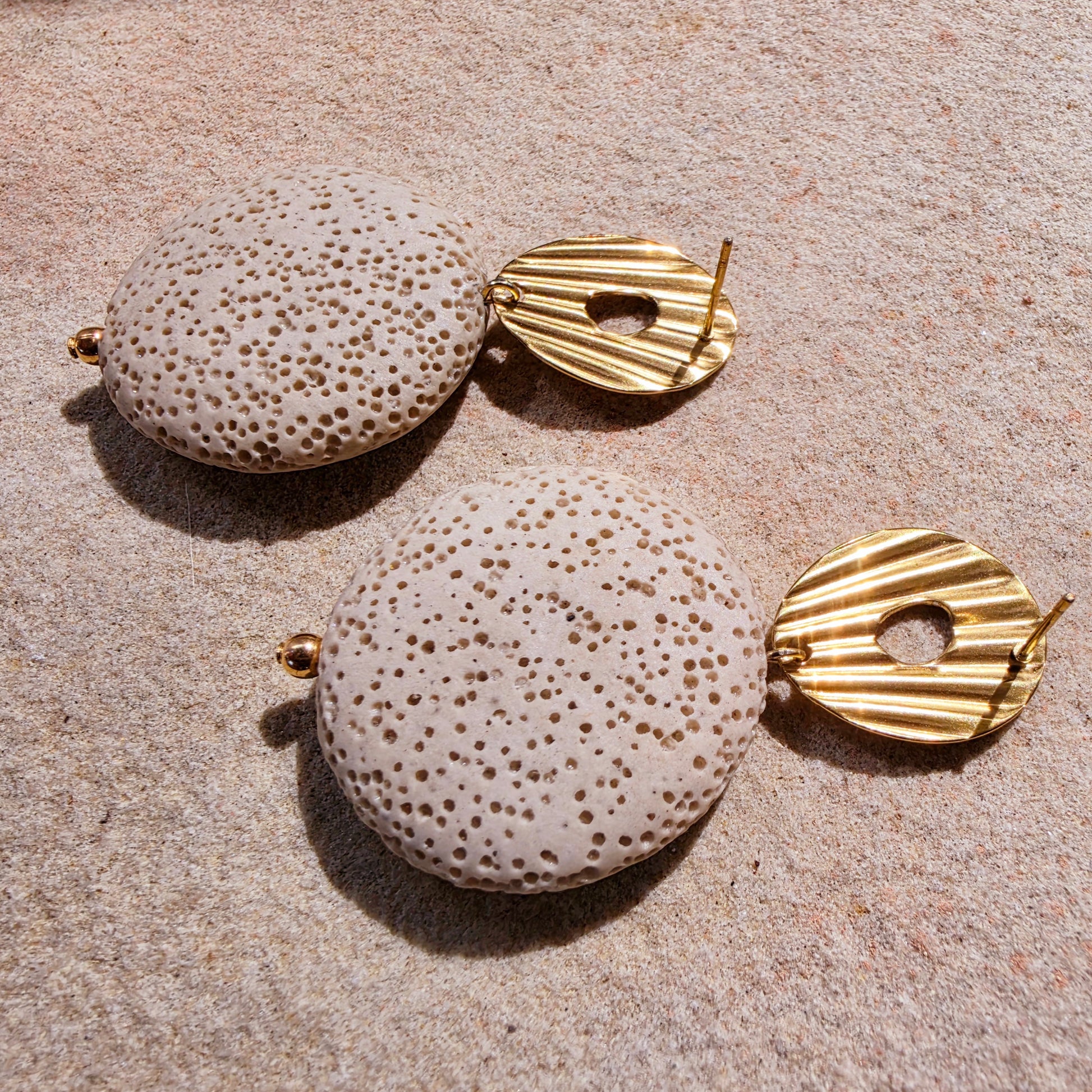 Close up image of the back of the Lumen earrings from the Relic collection, showing the coral like texture and gold plated stud closure.
