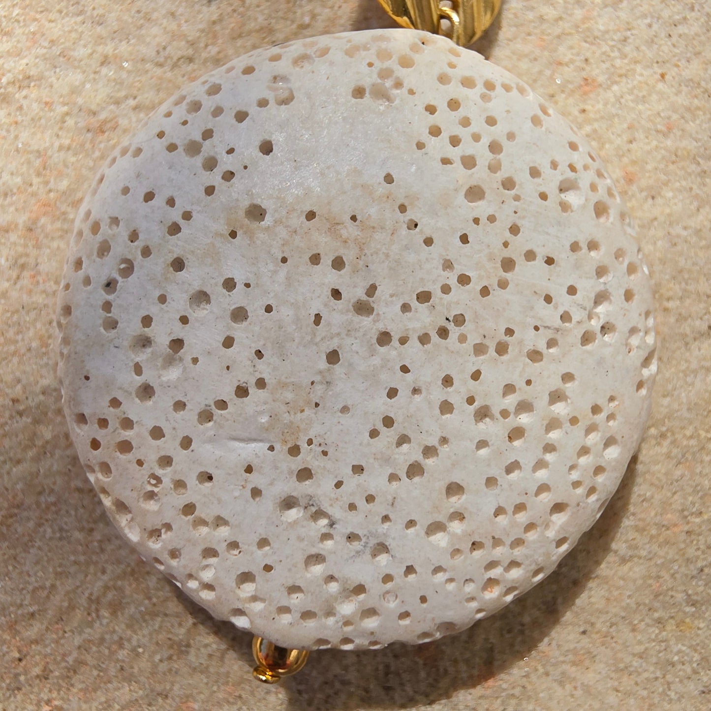 Close up view of the Relic Lumen earrings, showing the textured bead and natural discolouration.