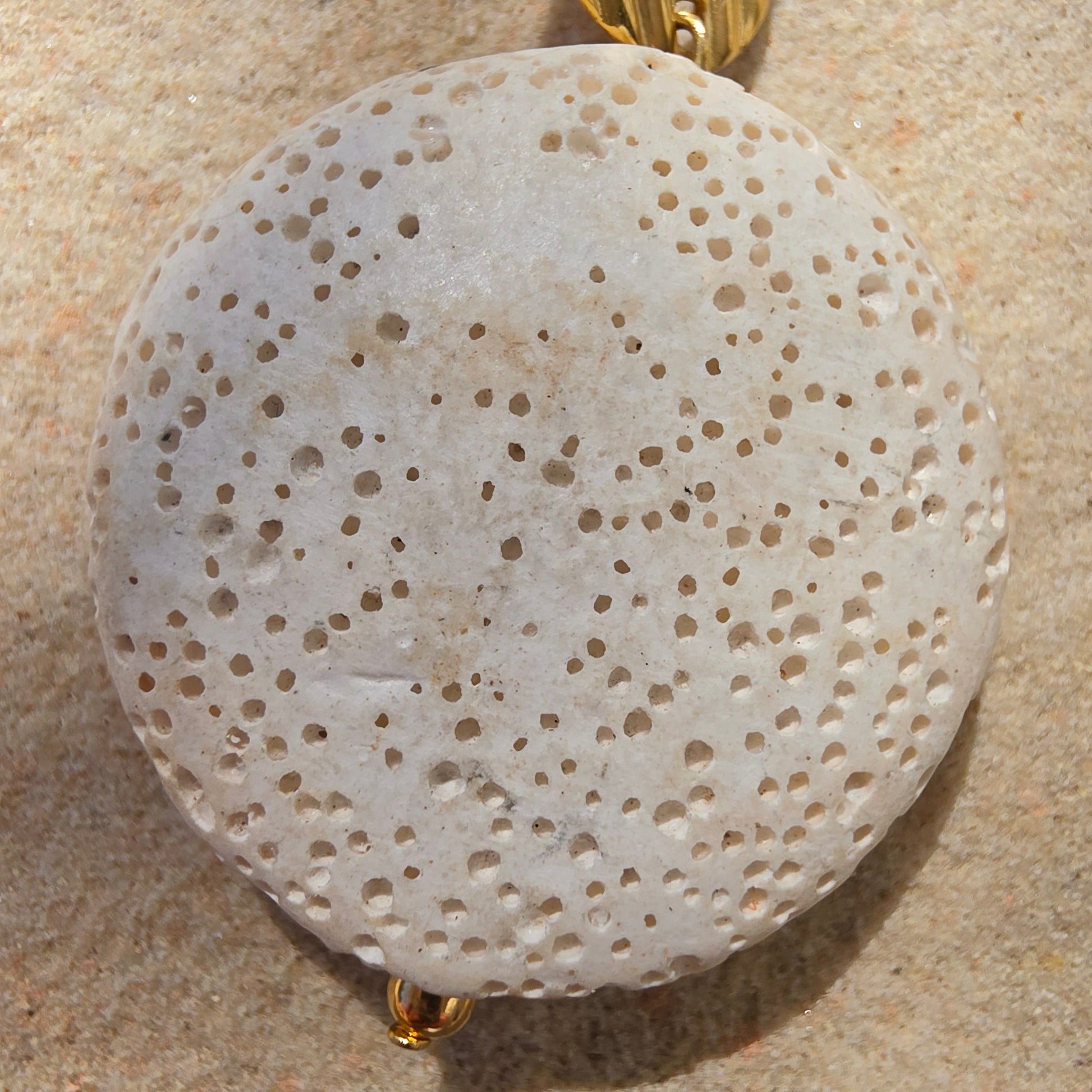 Close up view of the Relic Lumen earrings, showing the textured bead and natural discolouration.