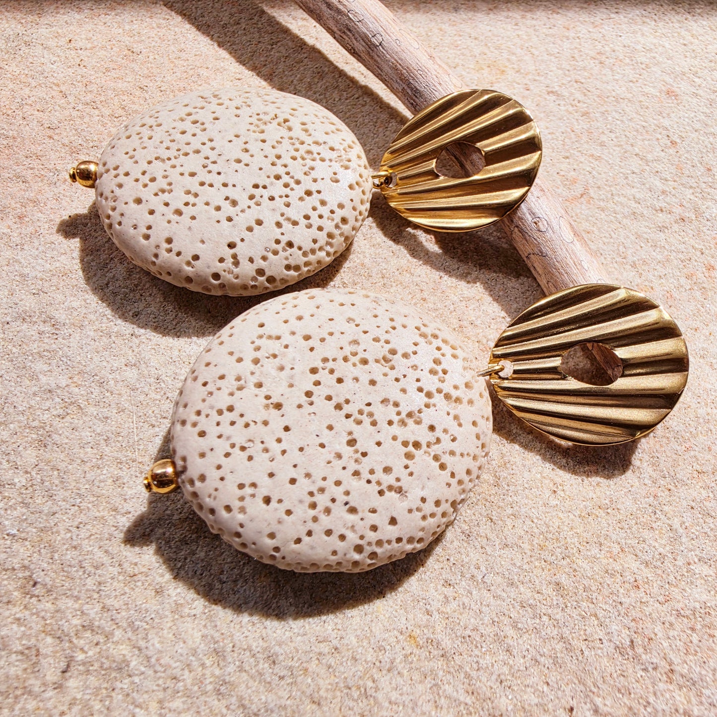 Close up image of the Lumen earrings from the Relic collection, showing the coral like texture and gold plated closure details.