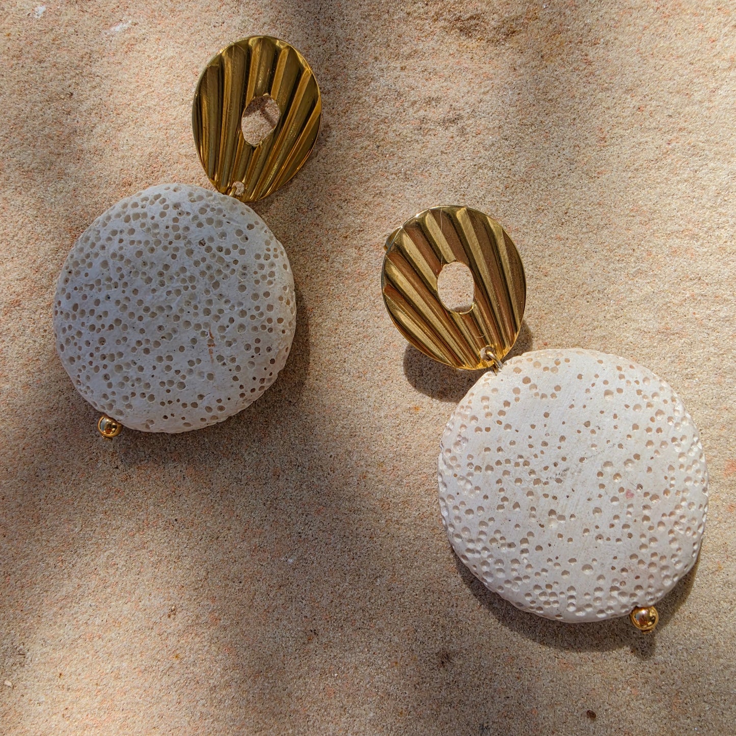 Close up view of the Lumen earrings , part of the Relic collection, showing the gold plated components and textured bead