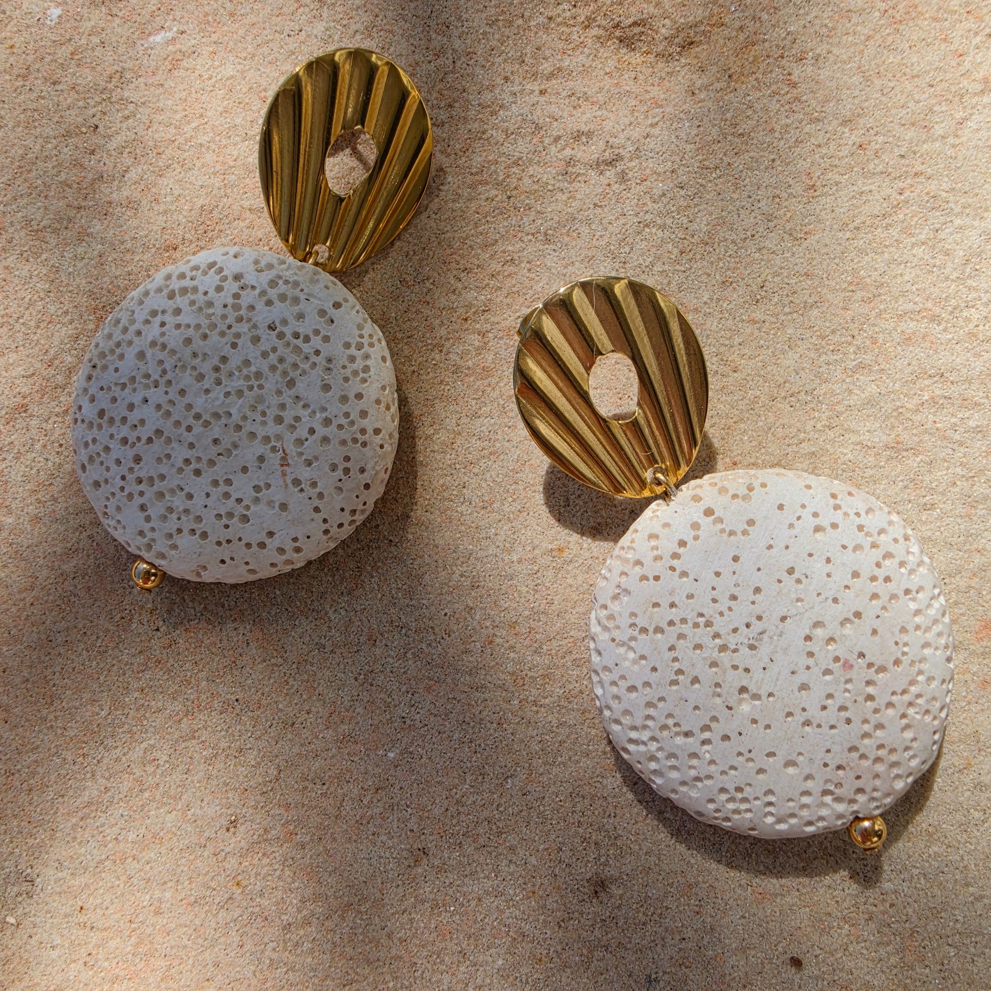 Close up view of the Lumen earrings , part of the Relic collection, showing the gold plated components and textured bead