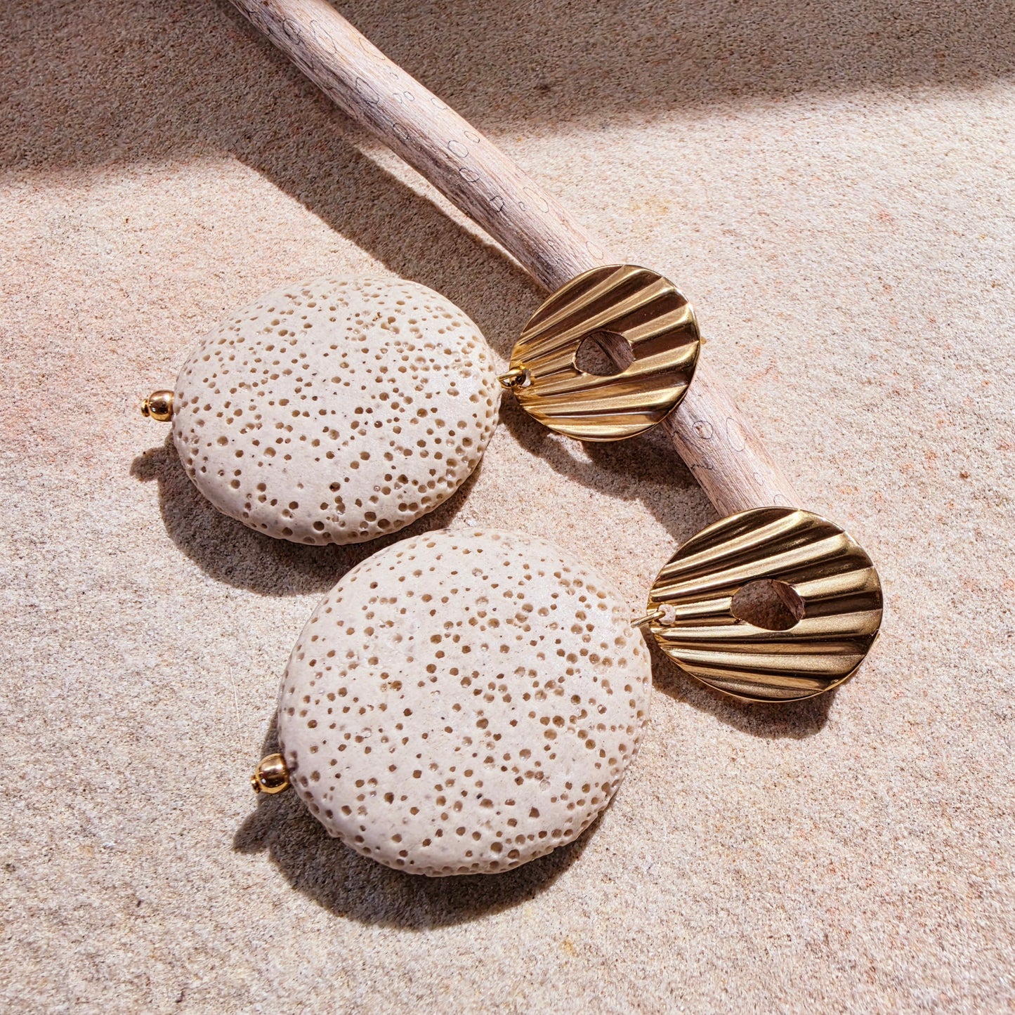 Image of the Lumen earrings from the Relic collection, showing the coral like texture and gold plated closure details.