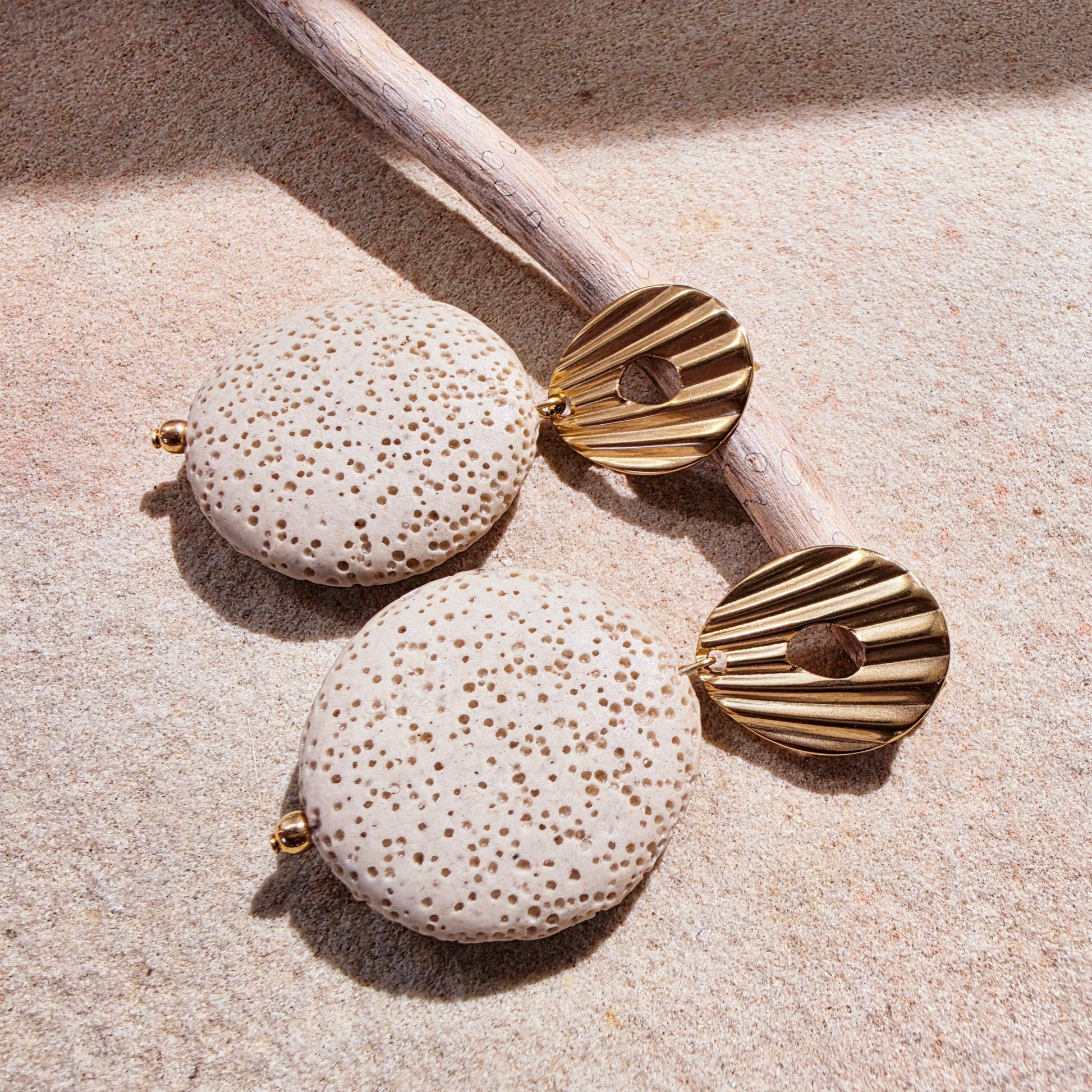 Image of the Lumen earrings from the Relic collection, showing the coral like texture and gold plated closure details.