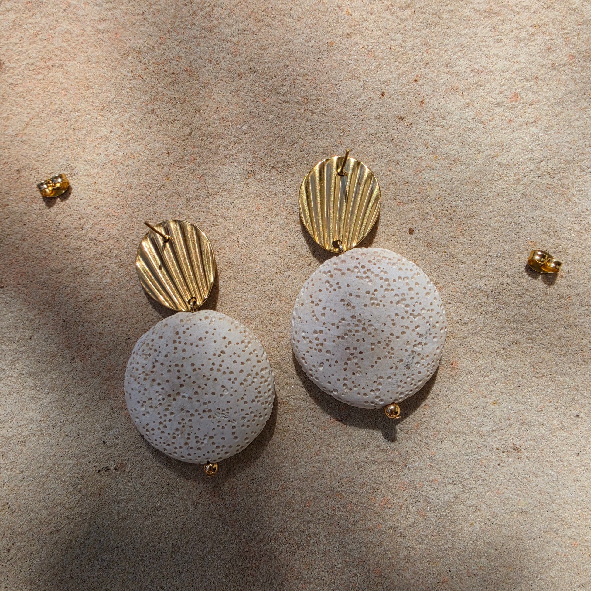 Close up view of the back of the Lumen earrings, showing the texture and gold plated stud components.