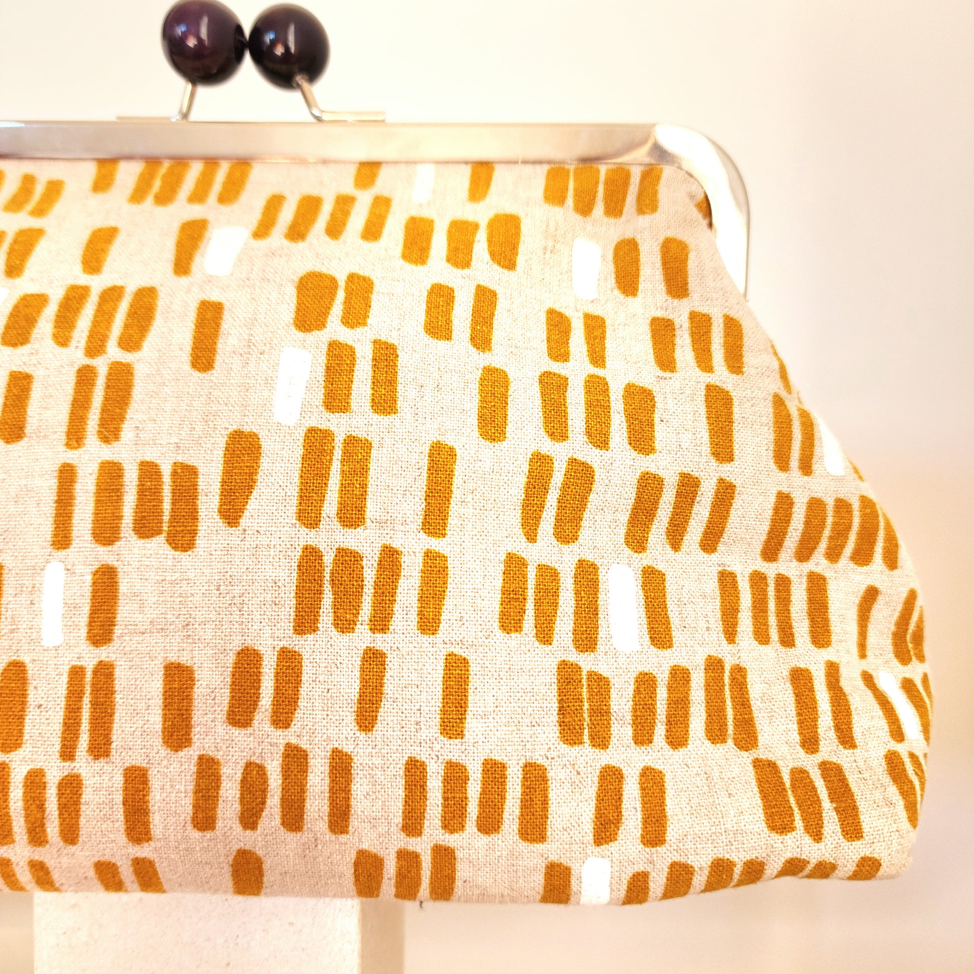 A close-up view of the retro clutch bag's line design in mustard colour.