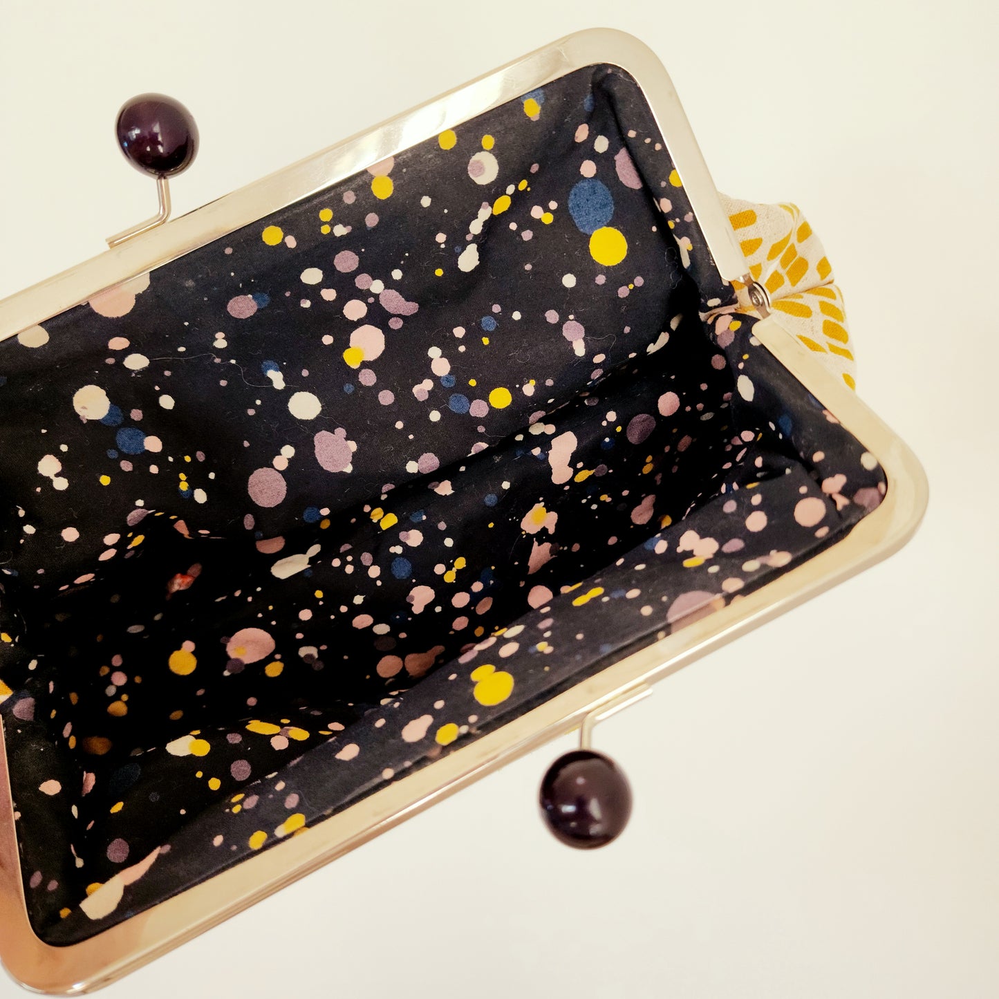 The inside view of the retro clutch bag, shoeing the galaxy style fabric.