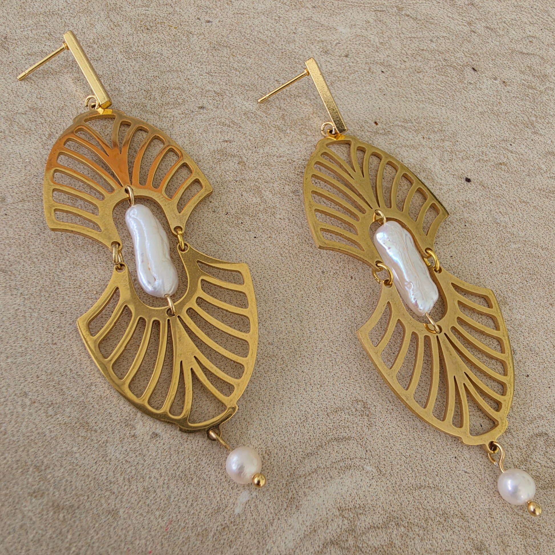 Close up view of the Ripple handmade pearl earrings showing the statement center pearl and gold plated components