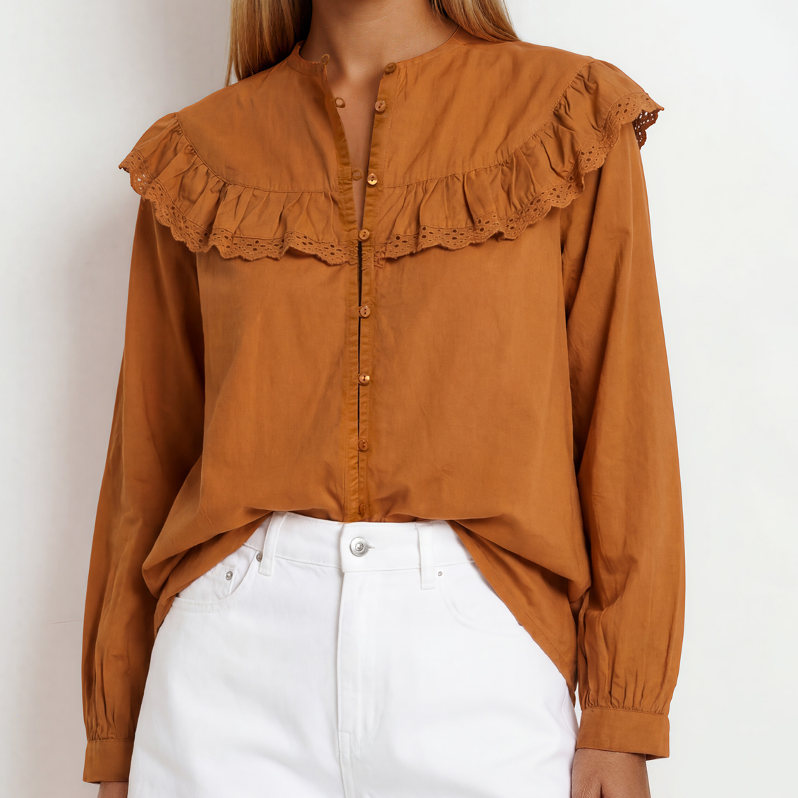 Image showing a woman wearing the rust coloured  long-sleeve blouse with a large ruffled lace collar and button front.