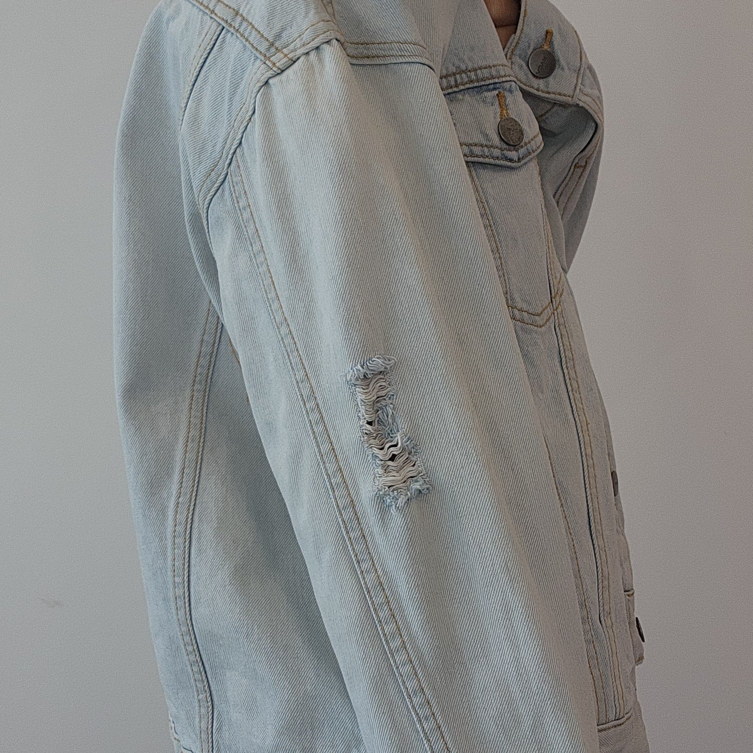 Side view of the RVCA distressed denim jacket showing the sleeve detail.