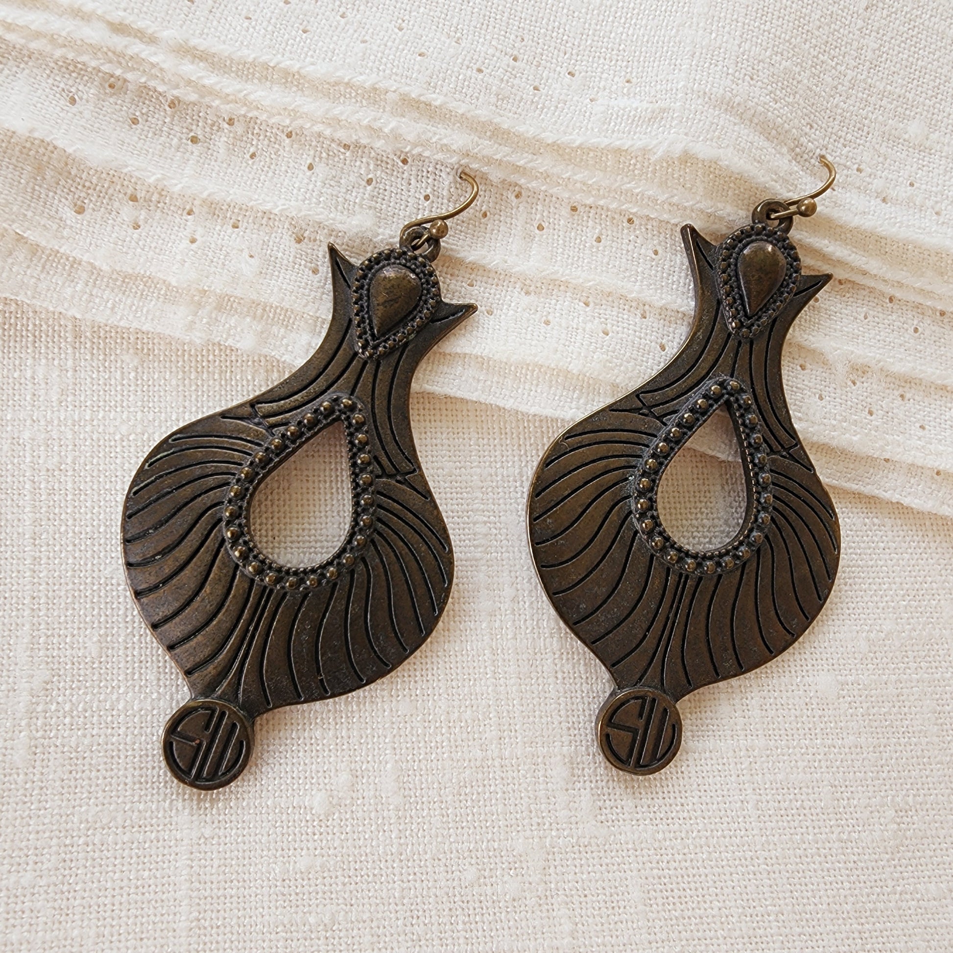 Close-up of Samantha Wills Monet’s Garden earrings showing antique-finish metal, curved carved lines and beaded trim.