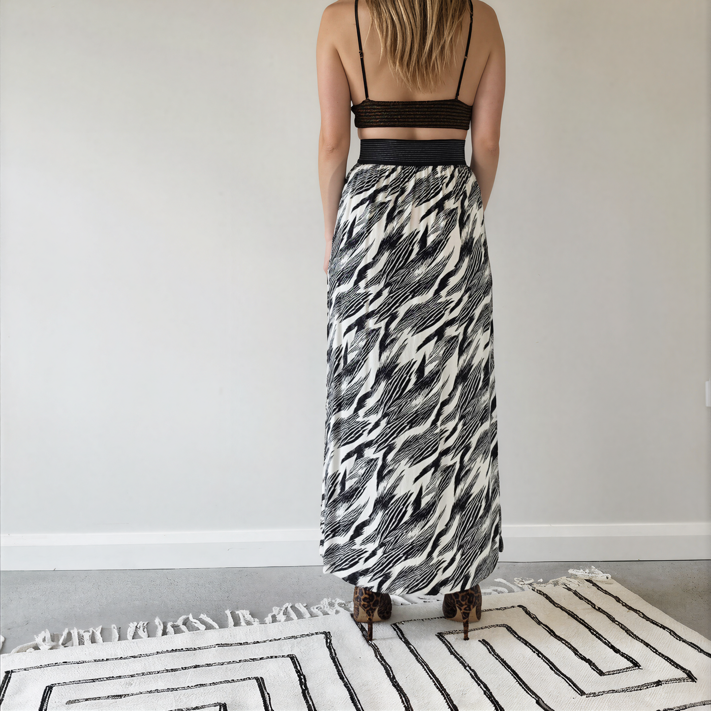 Back view of model wearing the Sass & Bide Bird of a Feather skirt, showing the monochrome print and wide metallic stripe waistband