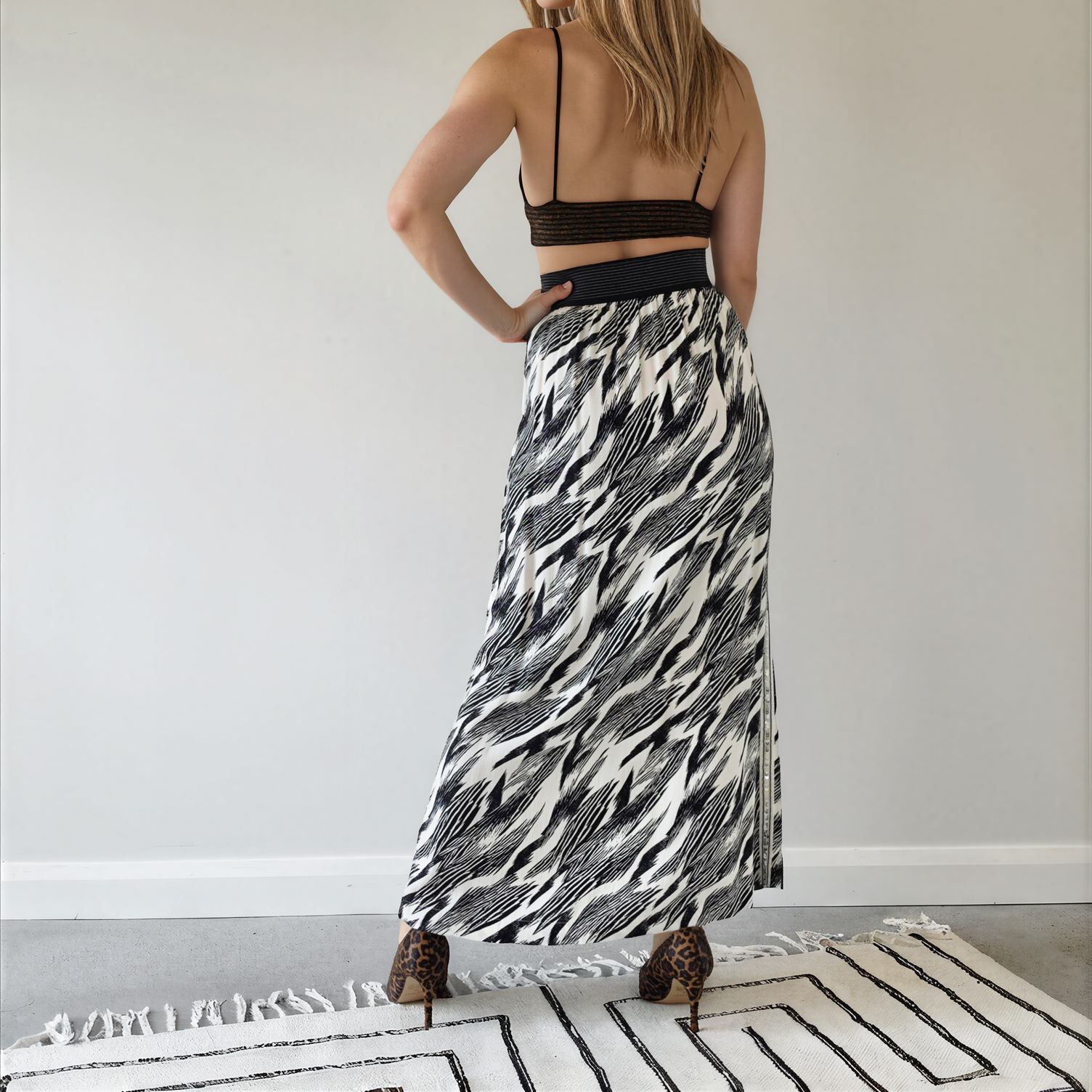 Back view of model wearing the Sass & Bide Bird of a Feather skirt, showing the monochrome print, sequin side strip and wide metallic stripe waistband