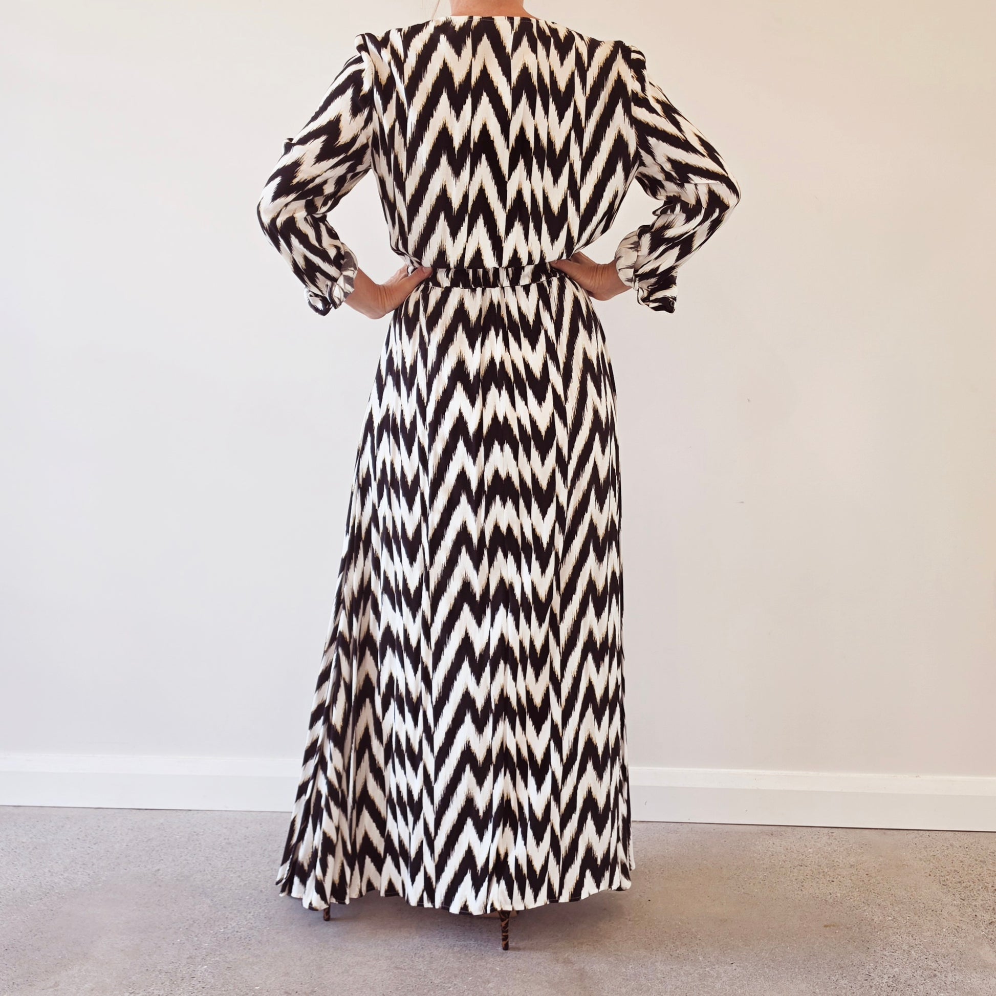 Back view of the Sass & Bide Broken Chevron maxi dress featuring the bold monochrome chevron print and flowing full-length skirt.