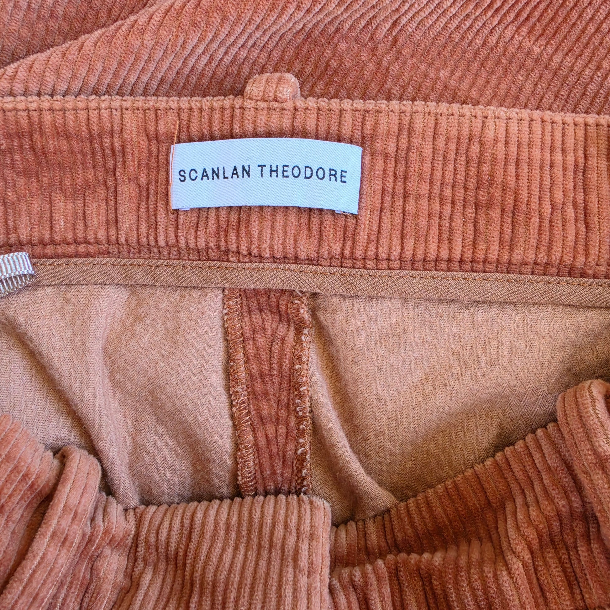 Image showing the brand tag Scanlan Theodore on the high waisted rust cord pants.