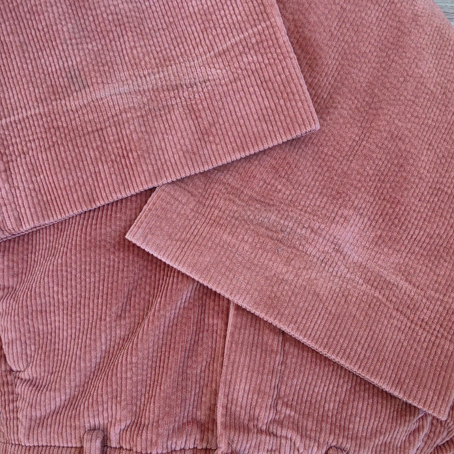 Close up view of the hemline on the Scanlan Theodore cord pants, showing the crushed fabric and small marks.