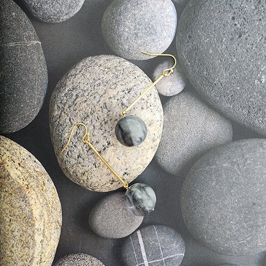 Image of the Shale gold plated handmade stone earrings, showing the simple round grey stone suspended from gold plated hooks. A Wilson Avenue exclusive.