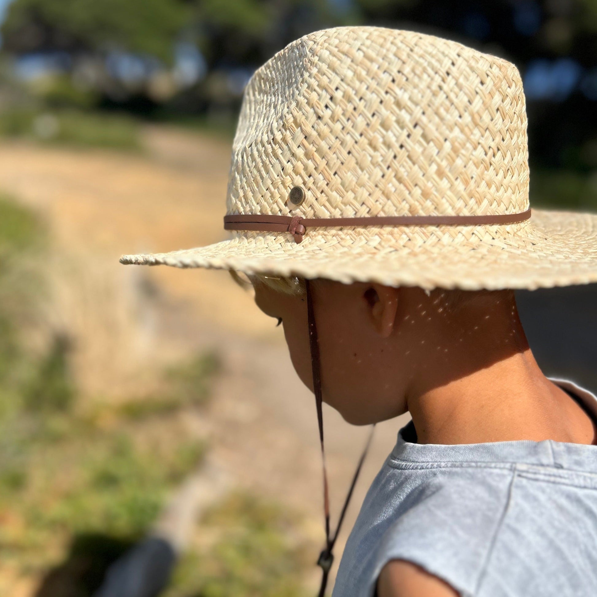 Back view of a small boy wearing the Shayd Mini Straw Hat