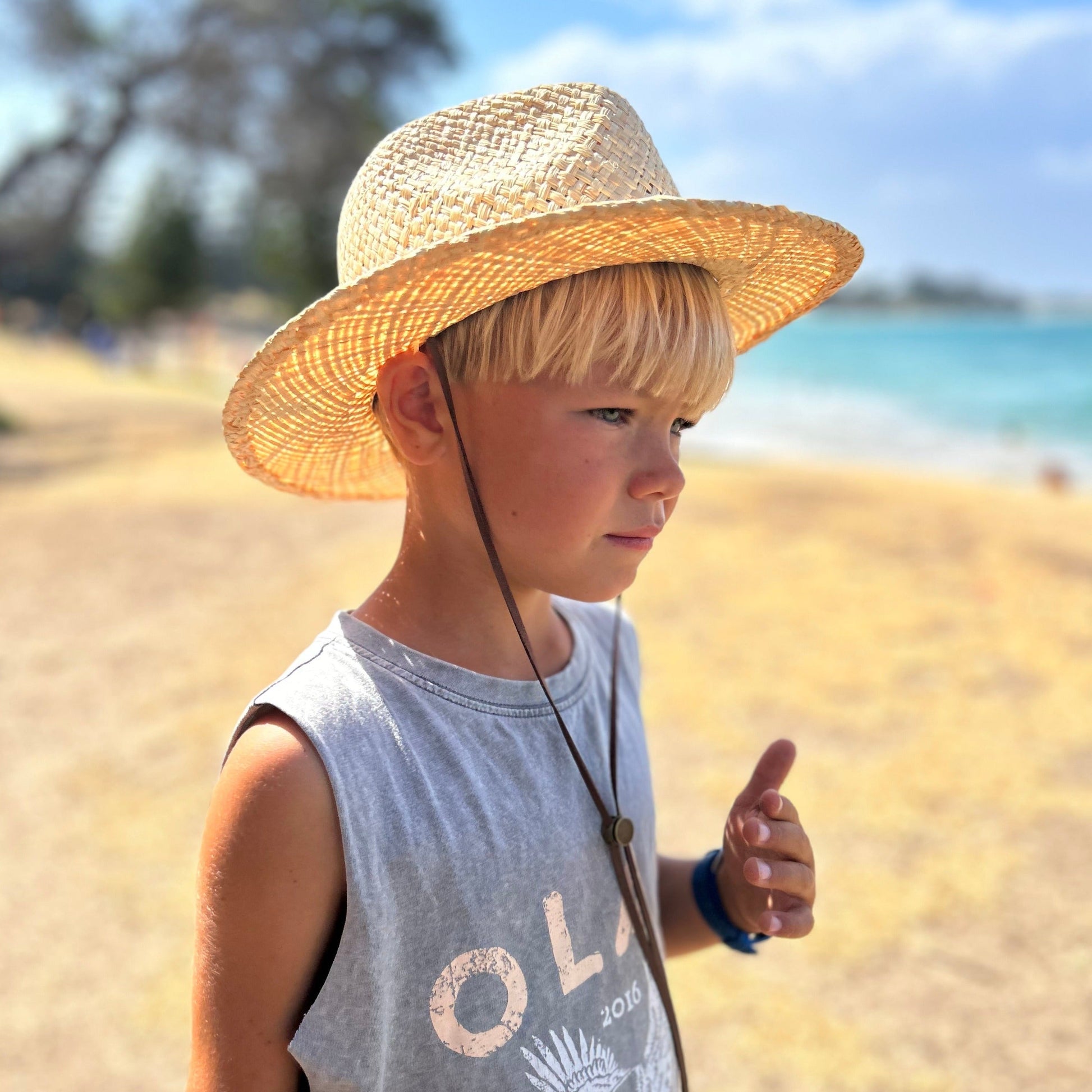 Image of a small child wearing one of the Shayd Mini Straw hats.