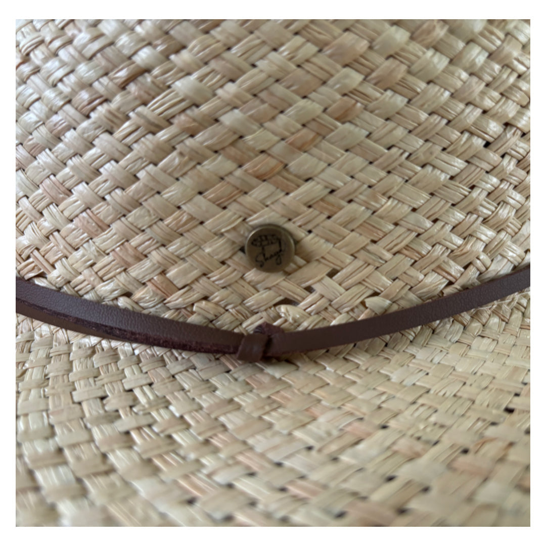 Close up view of the logo and leather strap on the Shayd straw hat