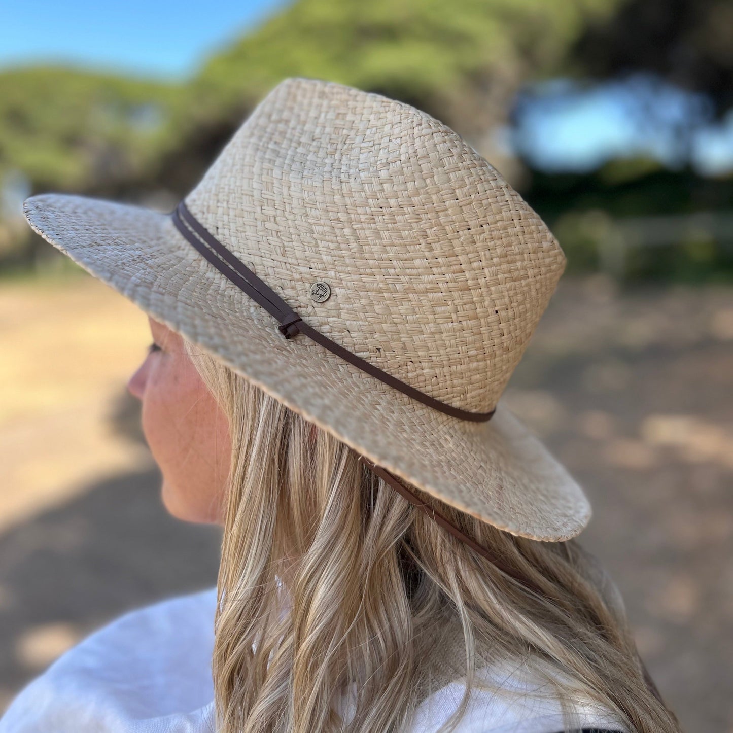 Woman wearing a Shayd straw hat showing the strap and side detail