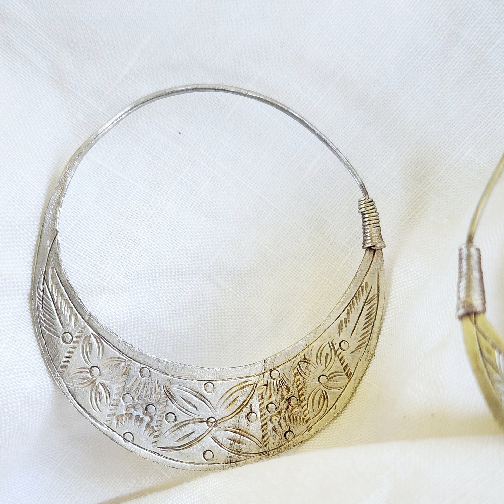 Front view of the Silver Strays etched crescent hoops, showing the oxidised, silver-worn patina and artisan detail.