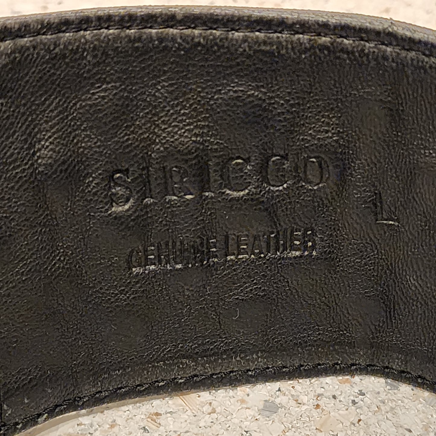 Close up of Sirocco leather belt showing the brand print and the genuine leather stamp.
