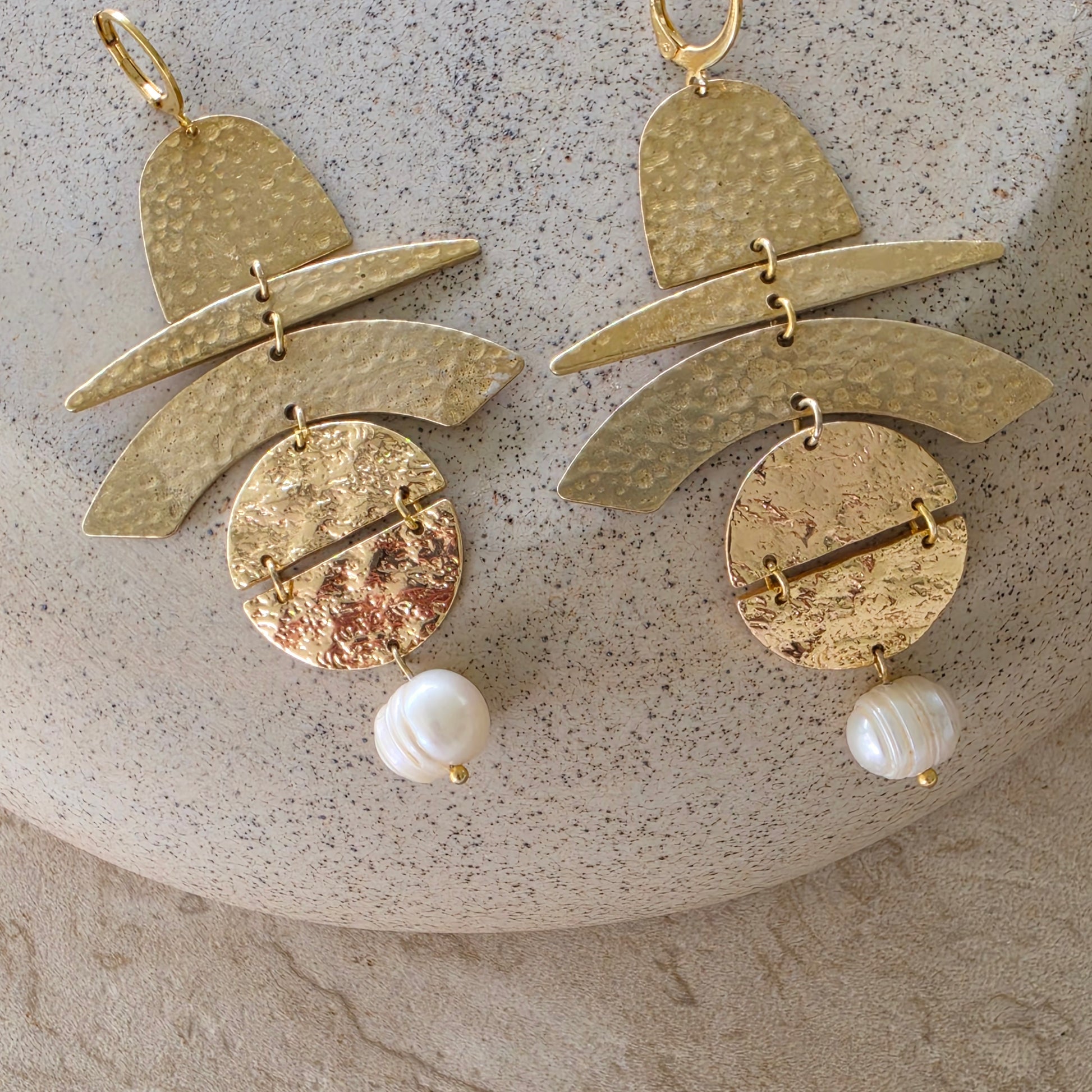 Front view of the Skupiti handmade earrings, showing the gold, brass and pearl components.
