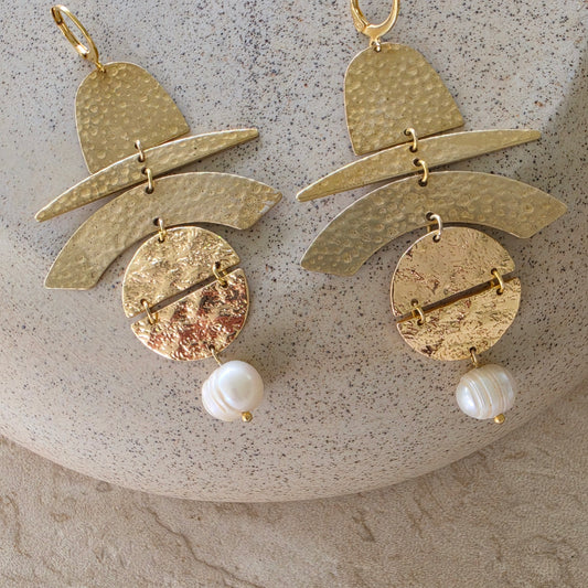 Front view of the Skupiti handmade earrings, showing the gold, brass and pearl components.