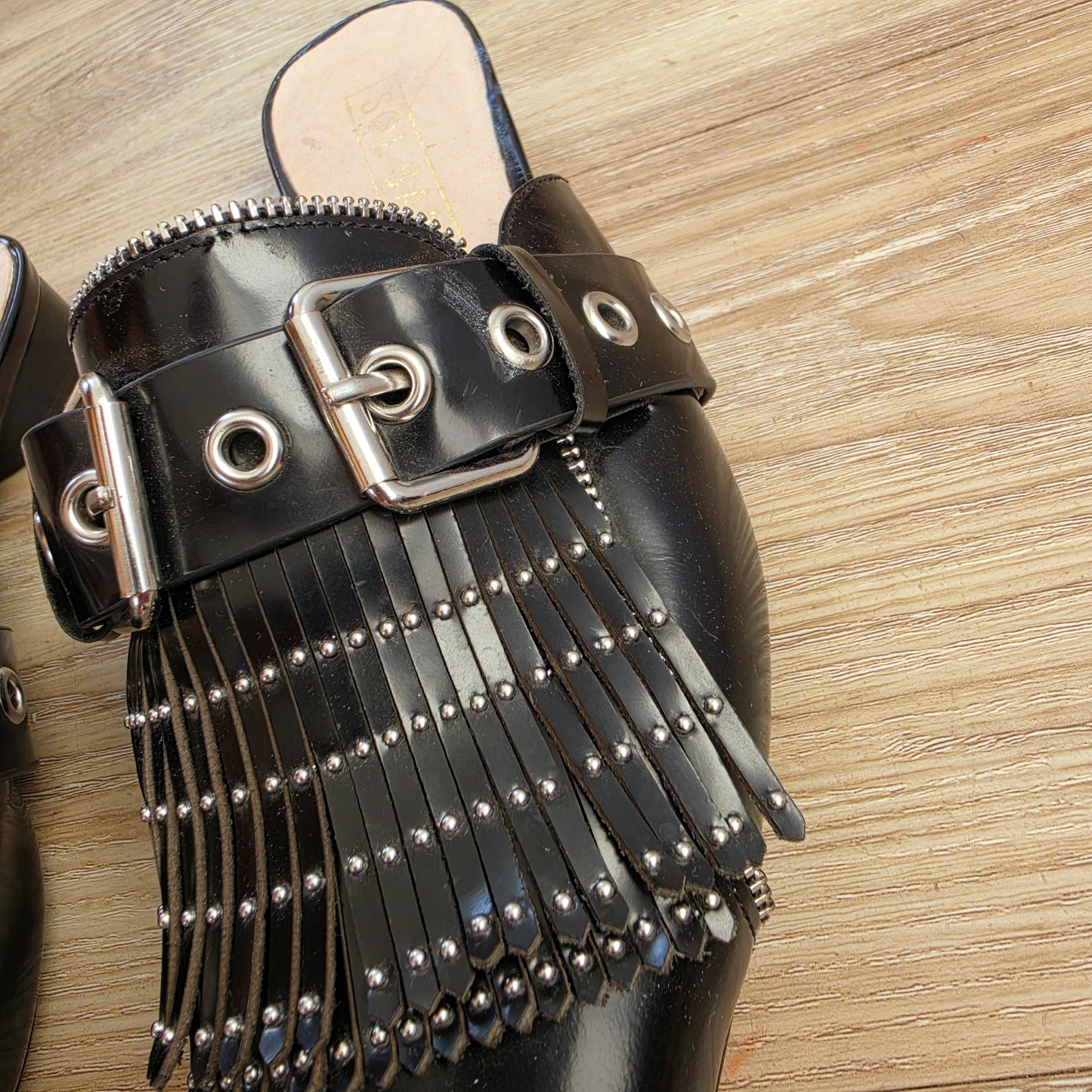 Close-up of silver buckle and eyelet hardware on Sol Sana Sadie slides, showing a small scuff near the eyelet.
