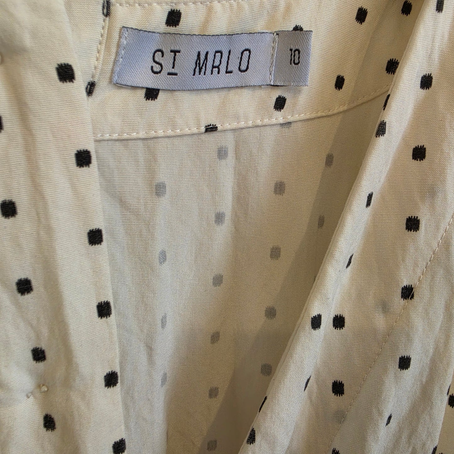 Close-up of the Maya playsuit with black polka dots, featuring a visible SI MRLO brand label and the size 10