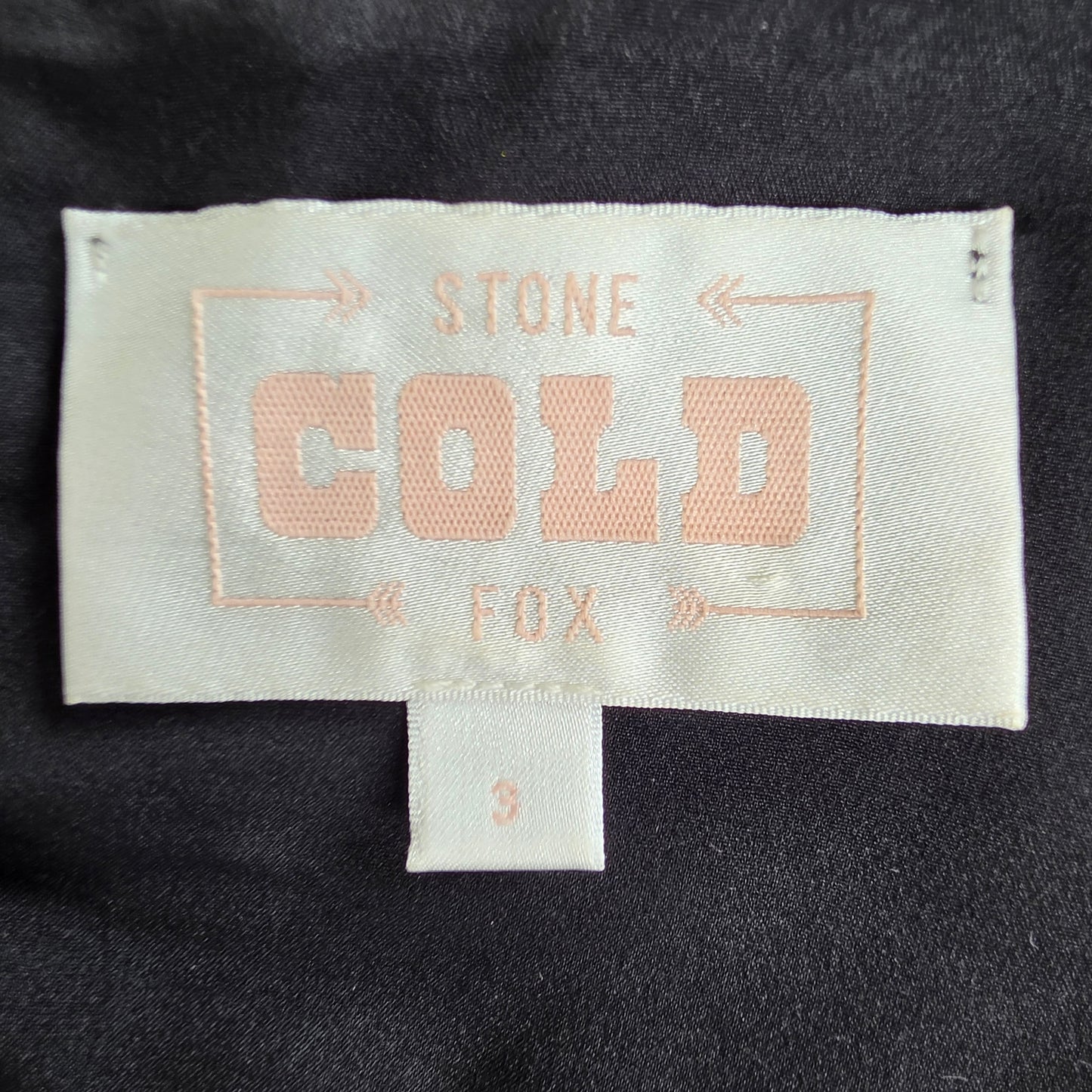 Close-up of a garment's interior neck label reading 'STONE COLD FOX' 