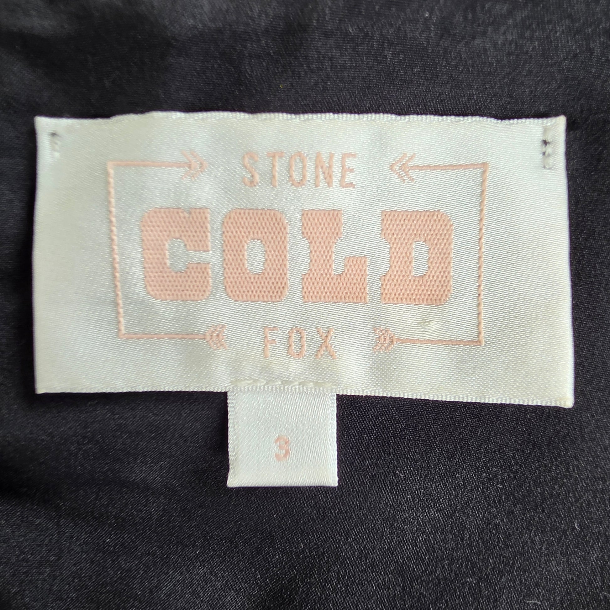 Close-up of a garment's interior neck label reading 'STONE COLD FOX' 