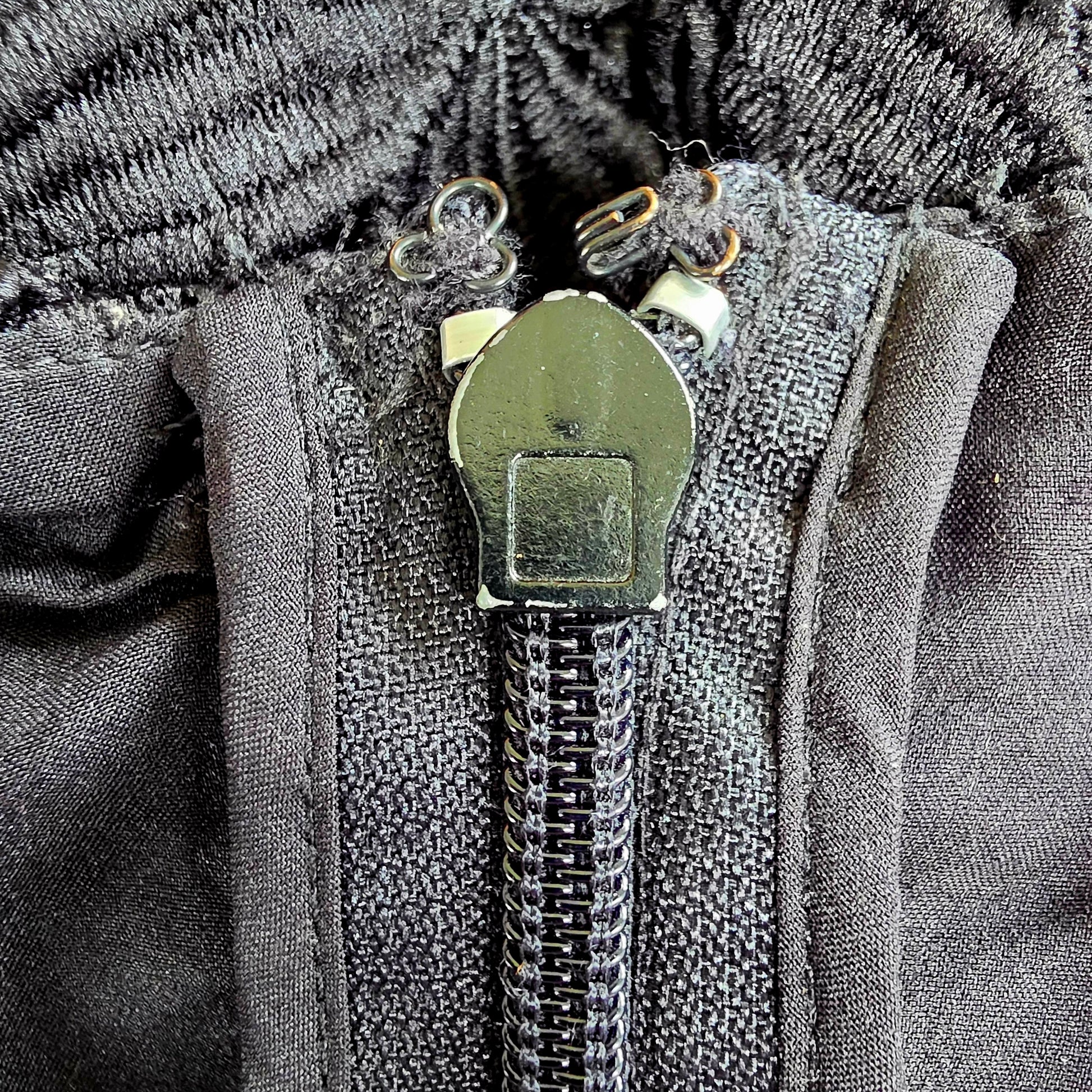 Close up of the zip on the Stone Cold Fox Saint Jumpsuit, showing the condition with slight chipping anf dicolouration of the hook and eye closure.