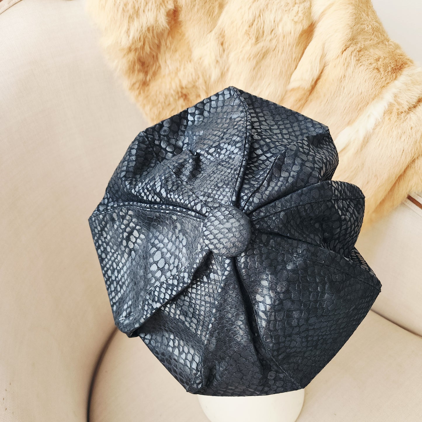 Top view of the vintage serpent-print suede beret with structured oversized silhouette.