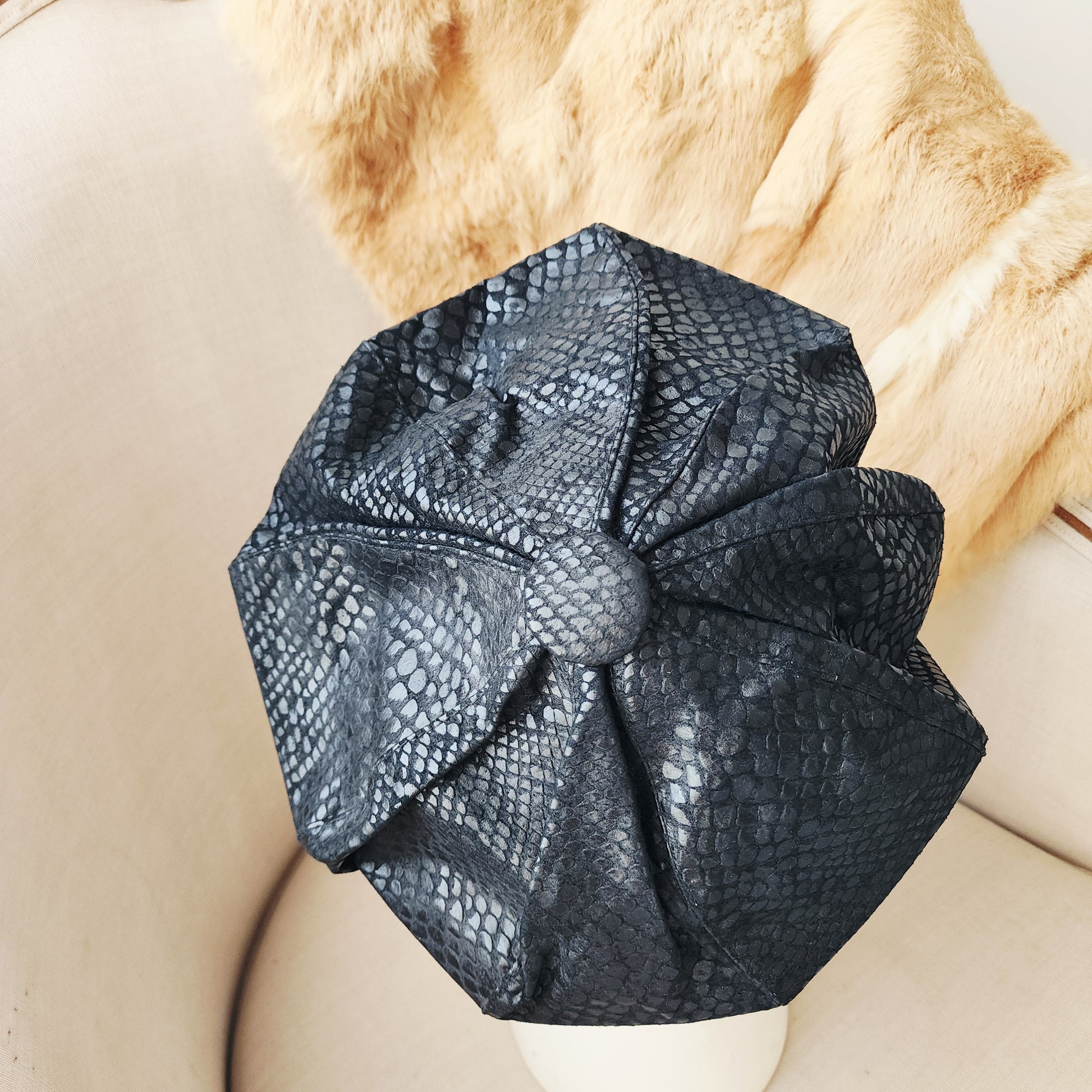 Top view of the vintage serpent-print suede beret with structured oversized silhouette.